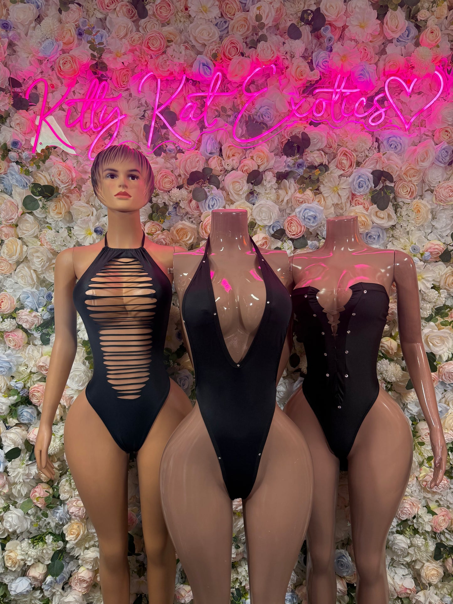 Black one-piece bodysuits with halter neckline and striped cutout front on models