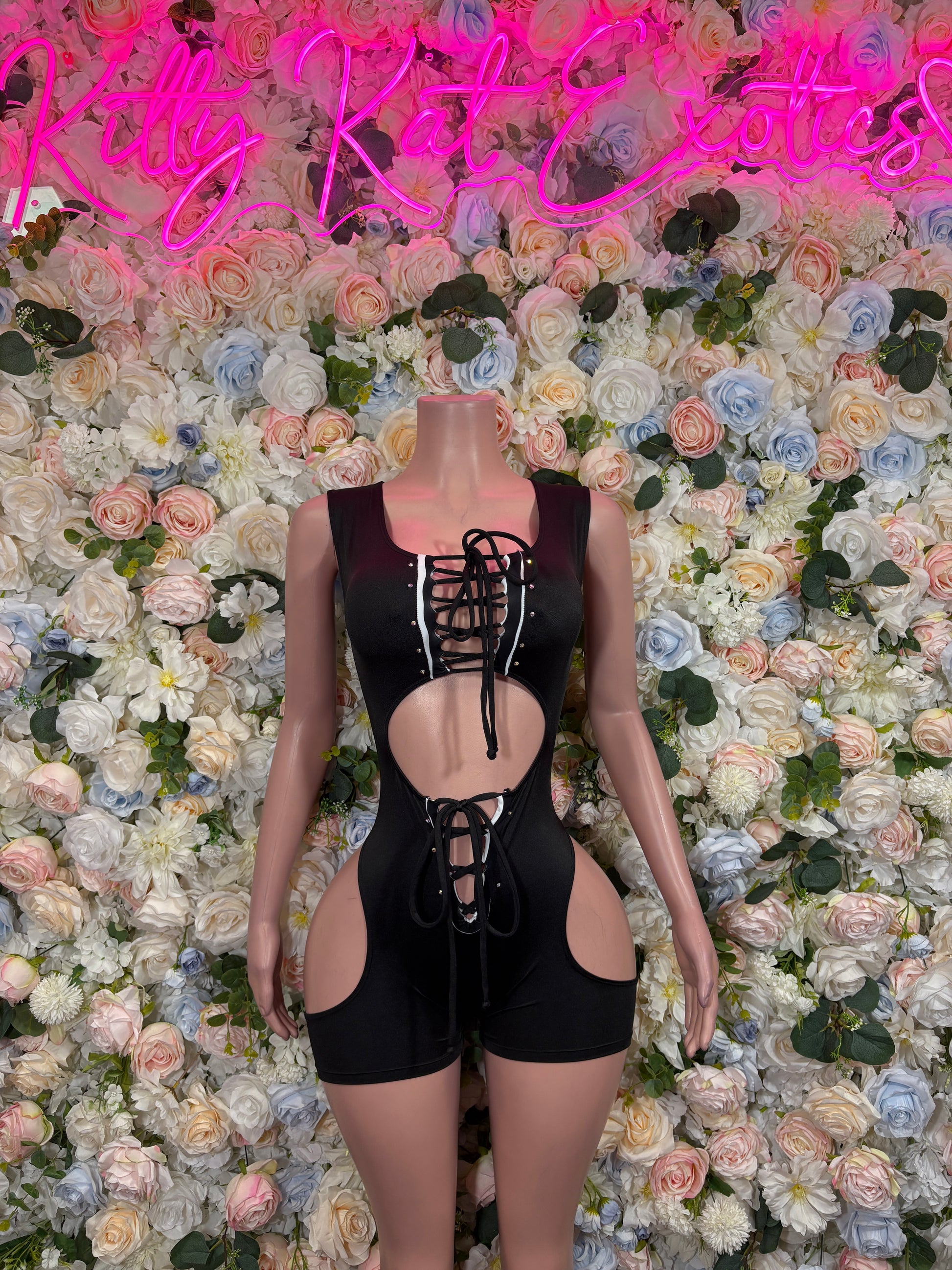 Black lace-up sleeveless romper with front cutouts and crisscross straps