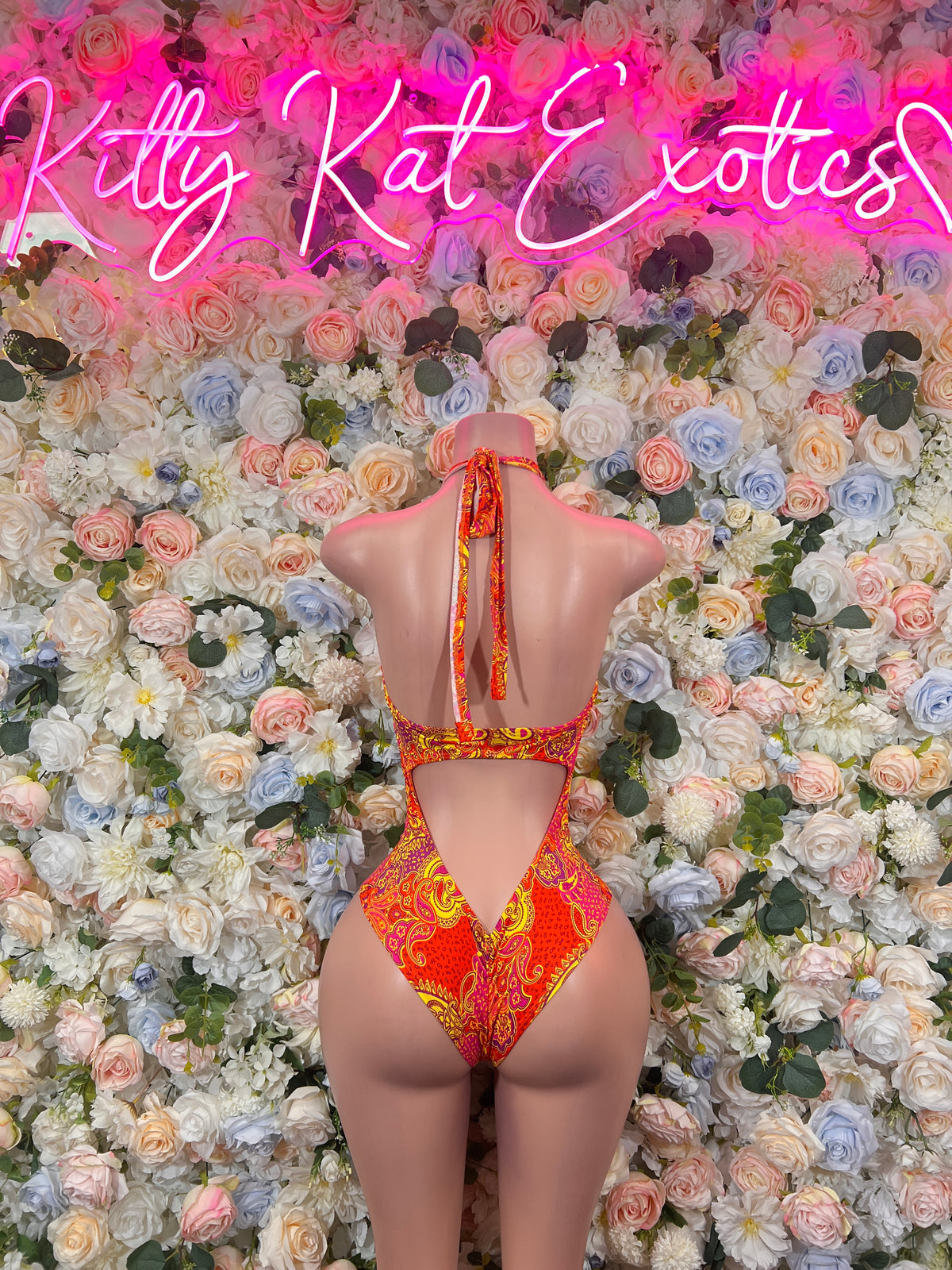 Orange patterned one-piece bodysuit, open back with tie straps, high-cut leg