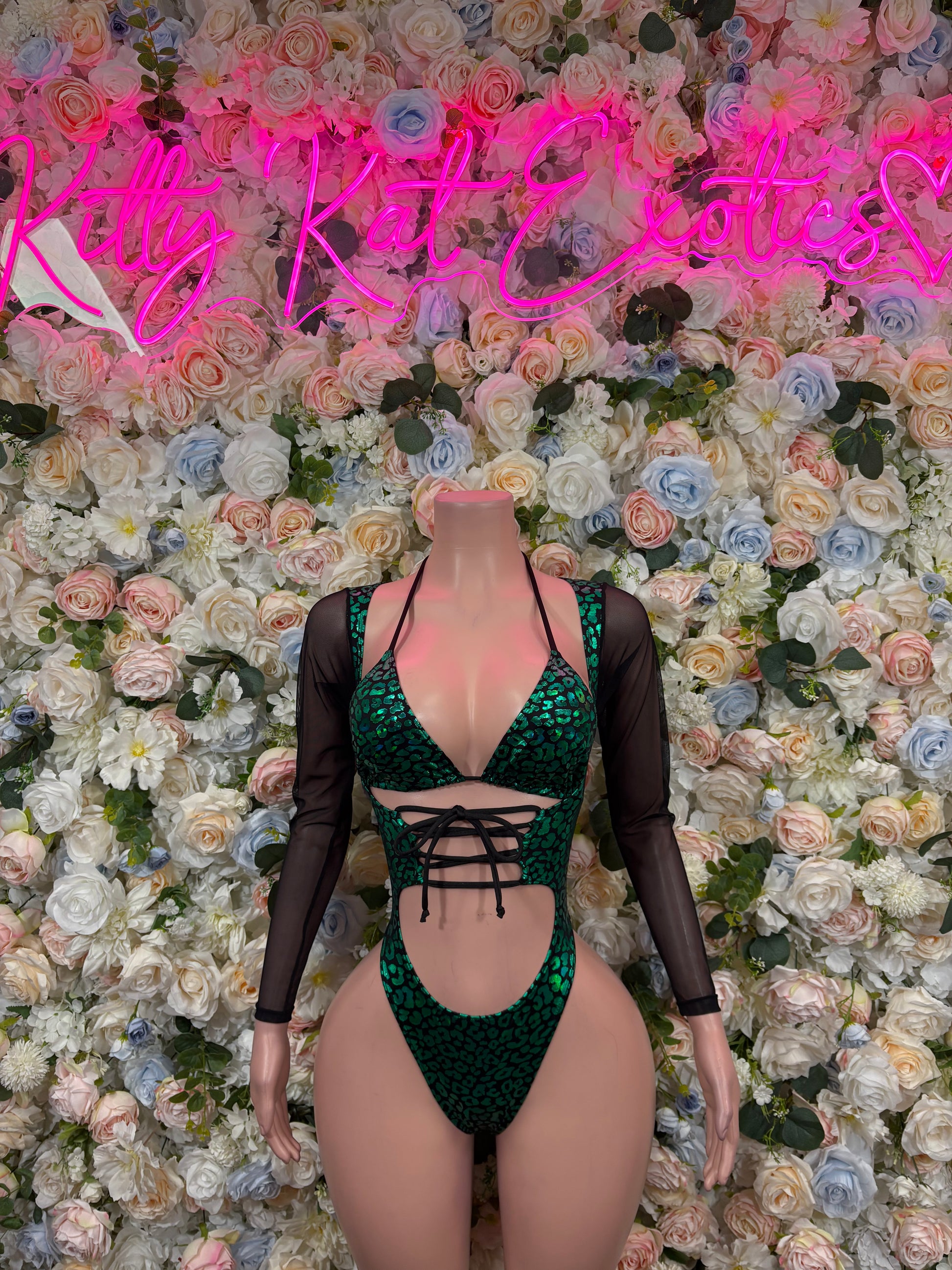 Green cheetah-print bodysuit with black sheer sleeves and lace-up front cutouts