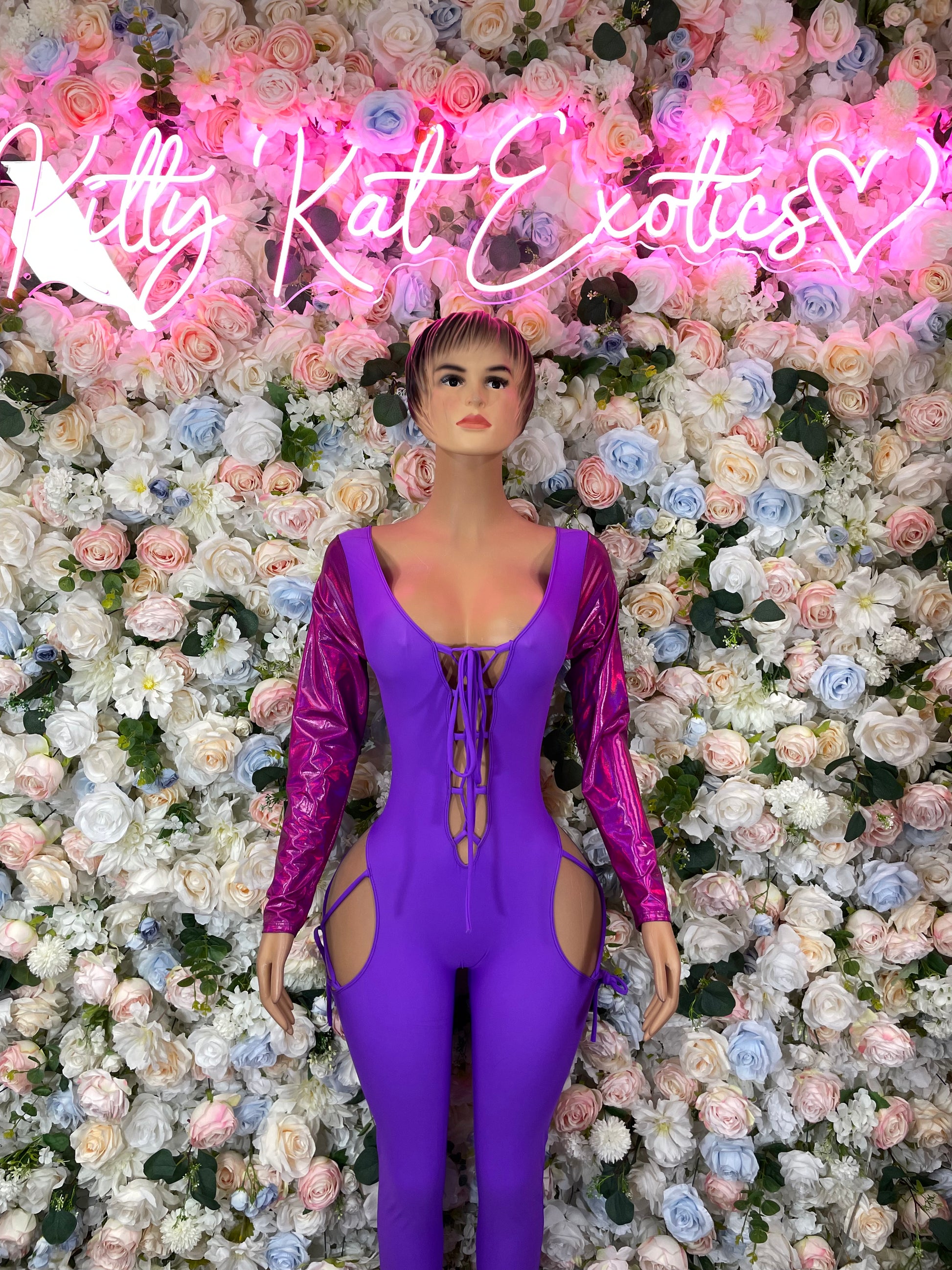 Purple one-piece bodysuit with long sleeves, V-neck, gold lace-up trim and front cutout