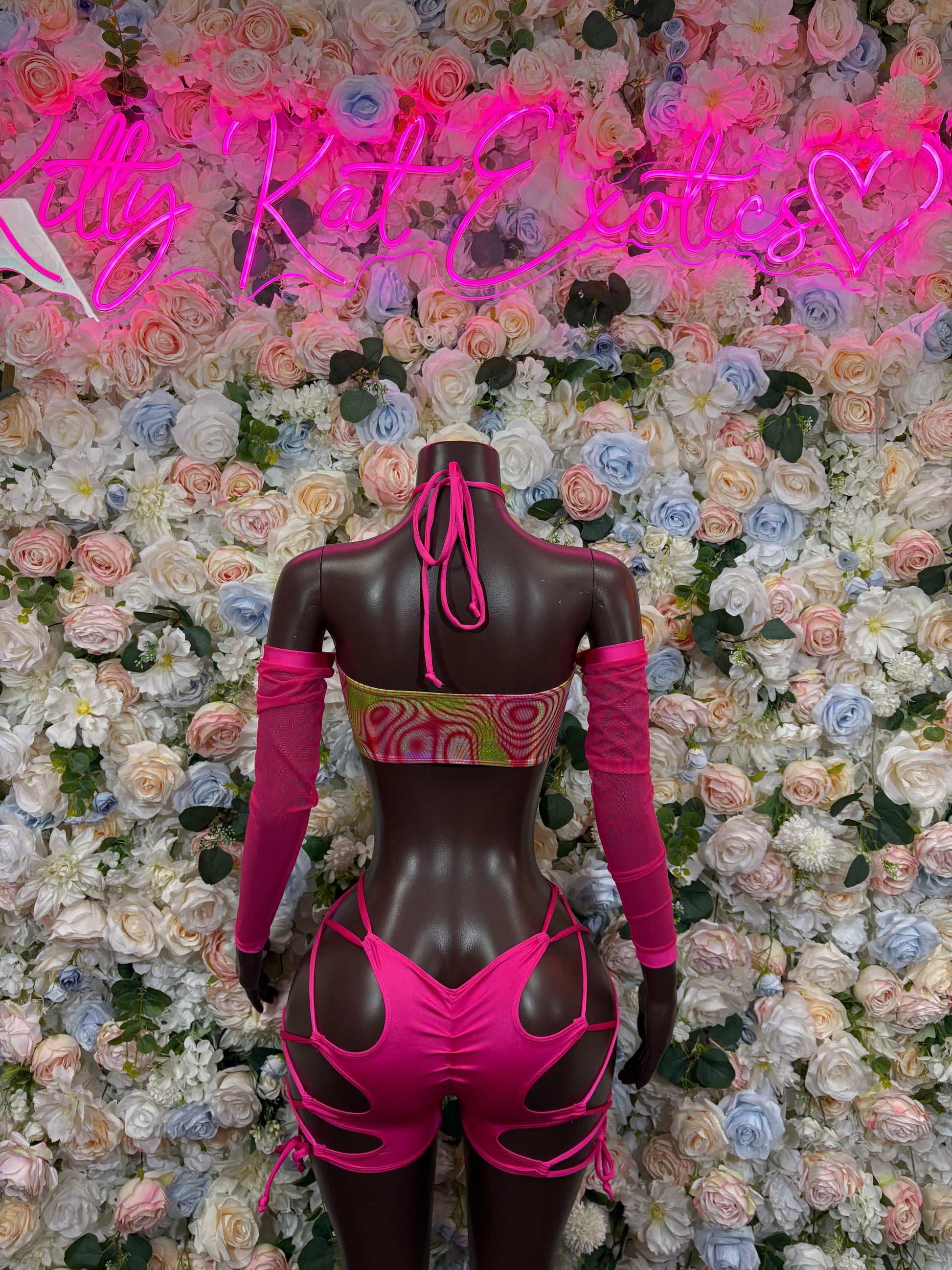 Pink and black holographic performer bodysuit with long sleeves, back ties, cutouts
