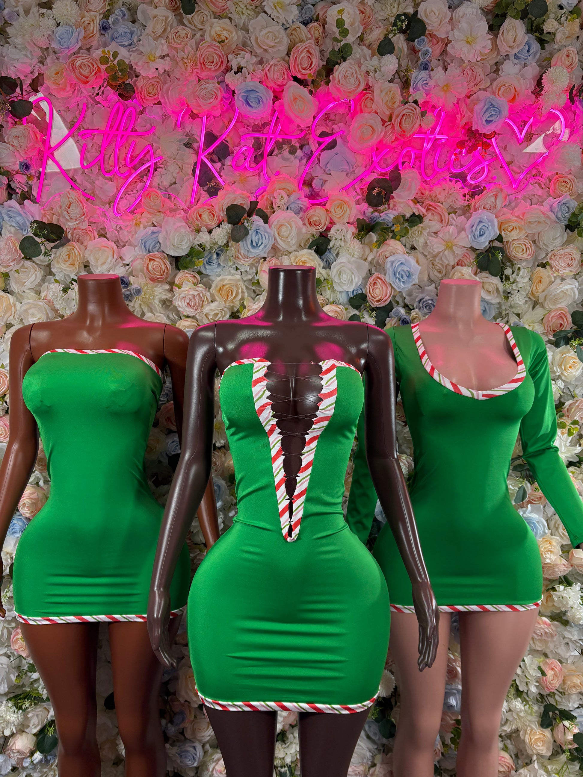 Three green Santa-style mini leotards with candy-cane chest stripes