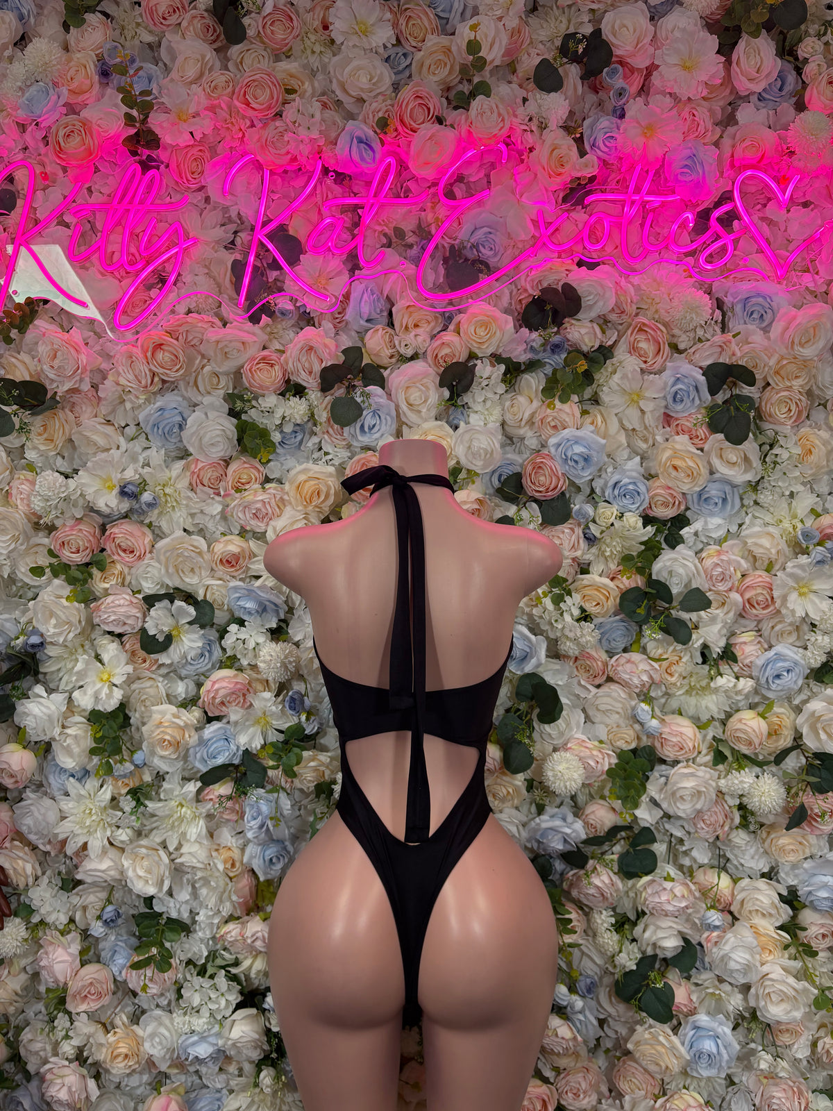Black one-piece bodysuit with open back and vertical strap cutouts