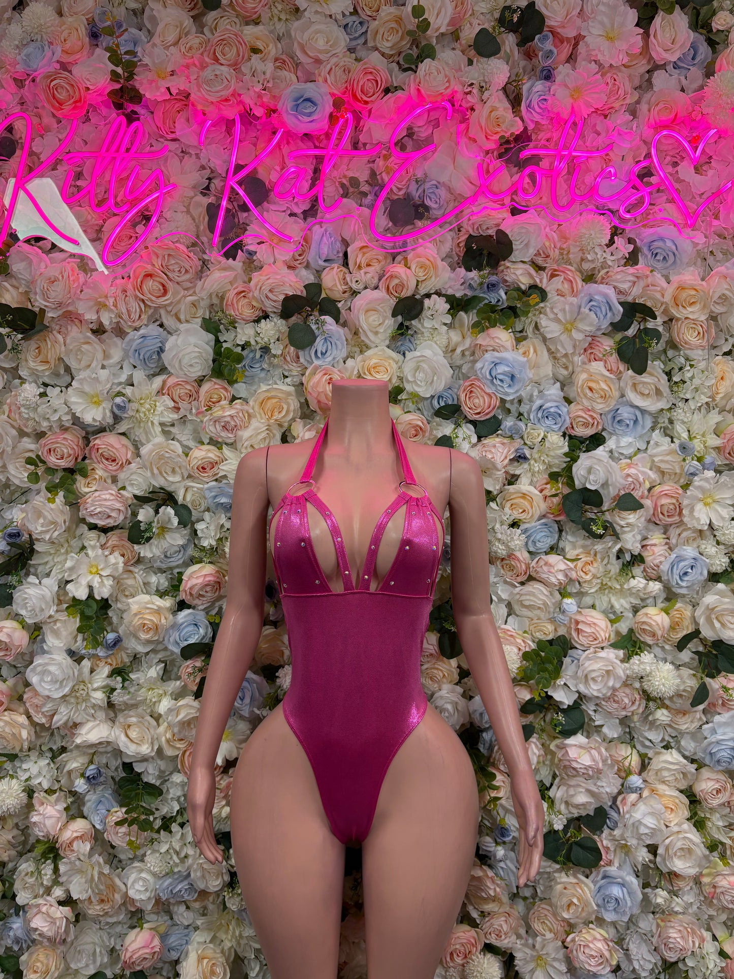 Pink metallic one-piece bodysuit with halter straps and high-cut leg openings