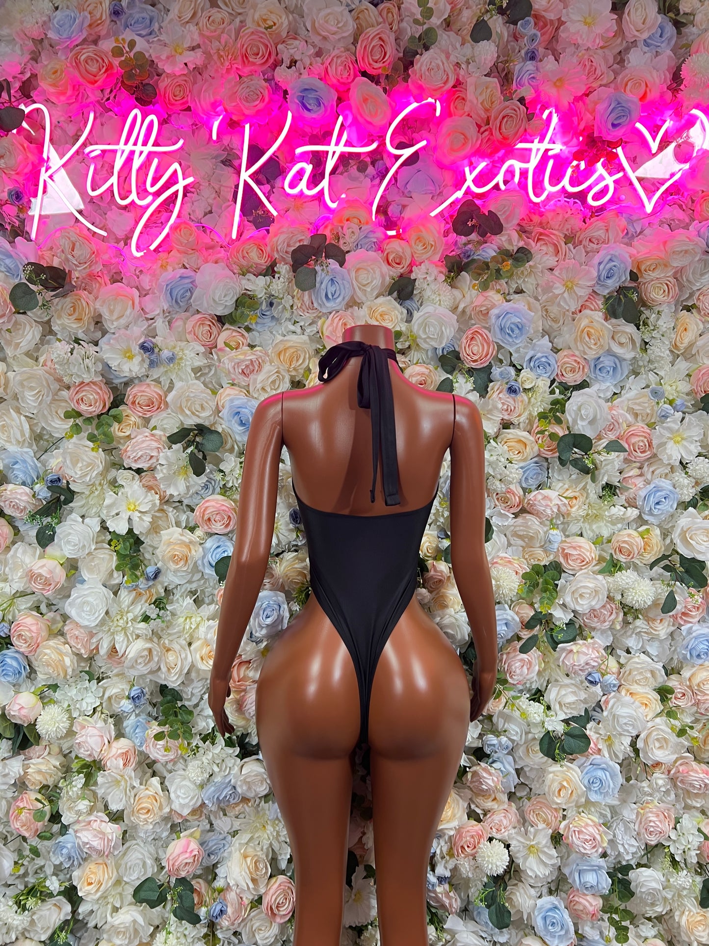 Black one-piece rave bodysuit with open back and vertical strap detail