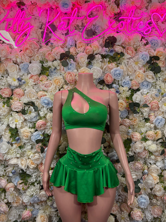 Green two-piece skirt set with strappy crop top and ruffled mini skirt on mannequin.