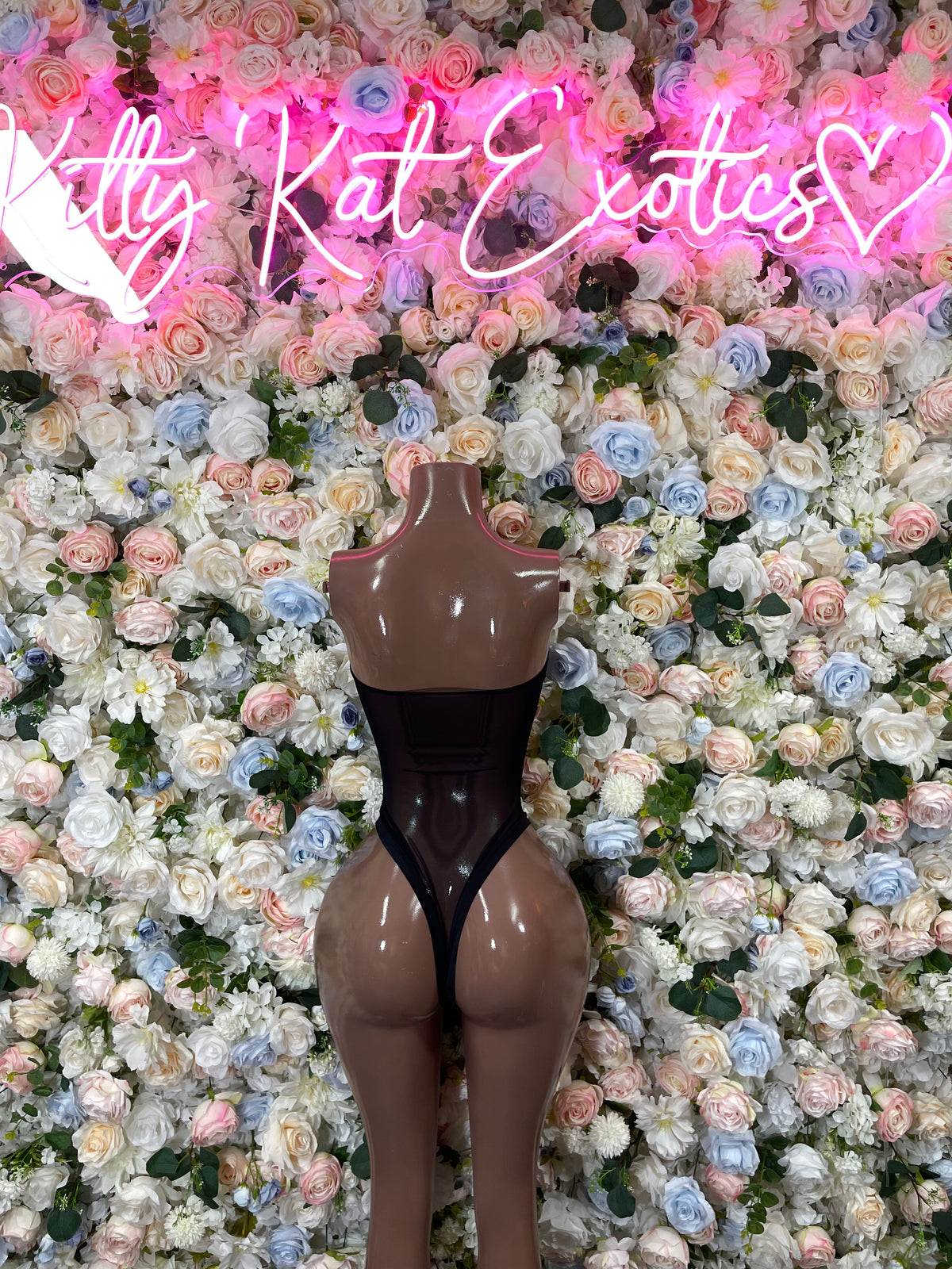 Black scoop-neck one-piece bodysuit on mannequin, sleeveless, high-leg cut