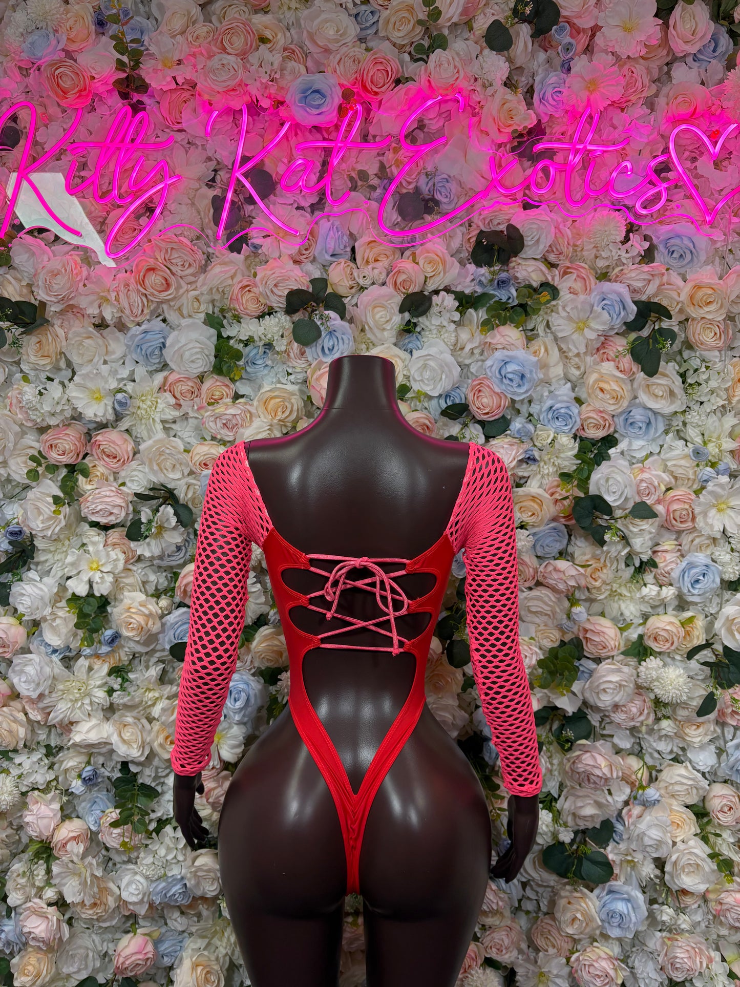 Pink mesh bodysuit with long sleeves, lace-up back, V-front and thong-style bottom