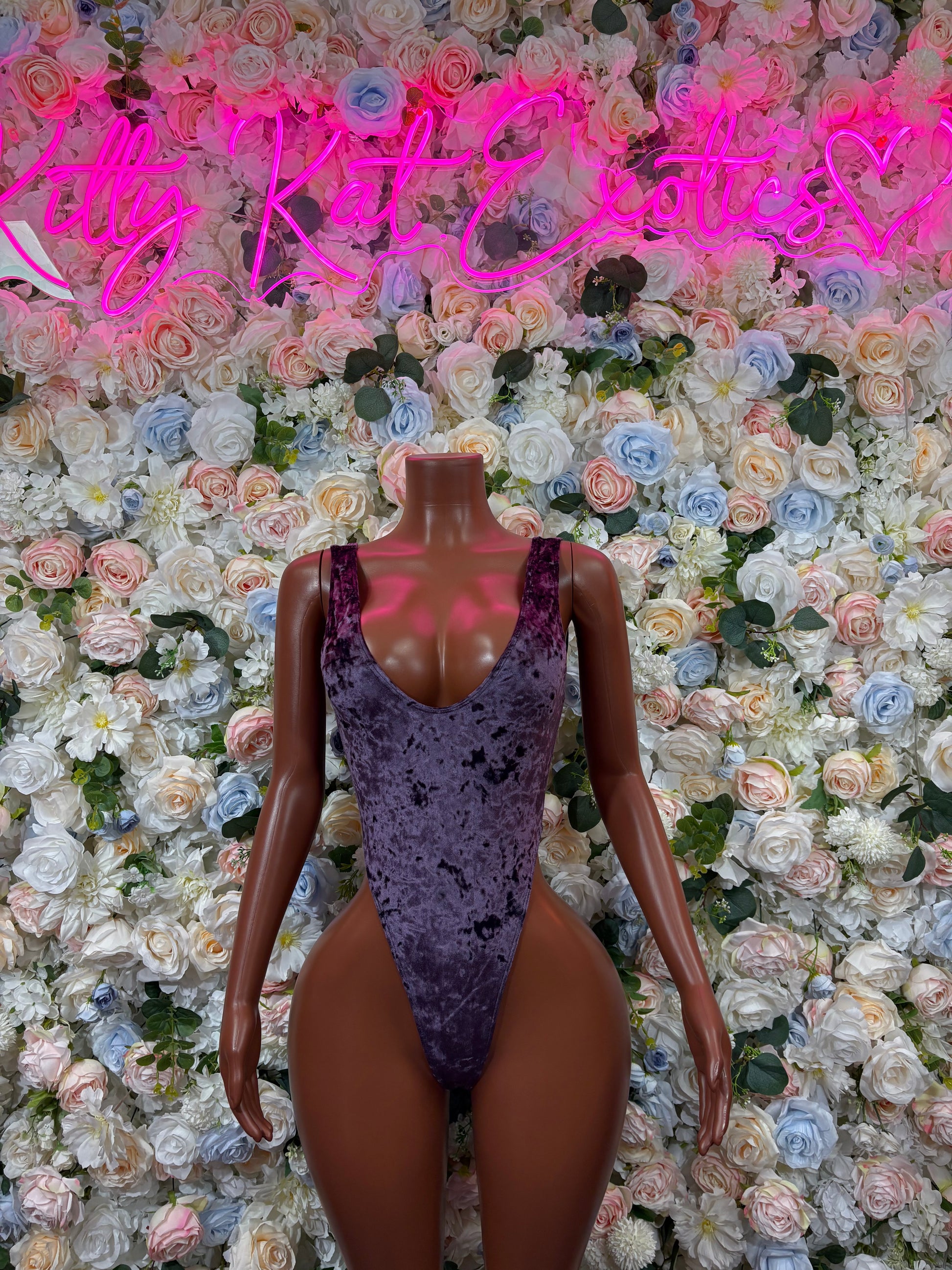 Purple velvet bodysuit with deep V neckline and high-cut leg openings