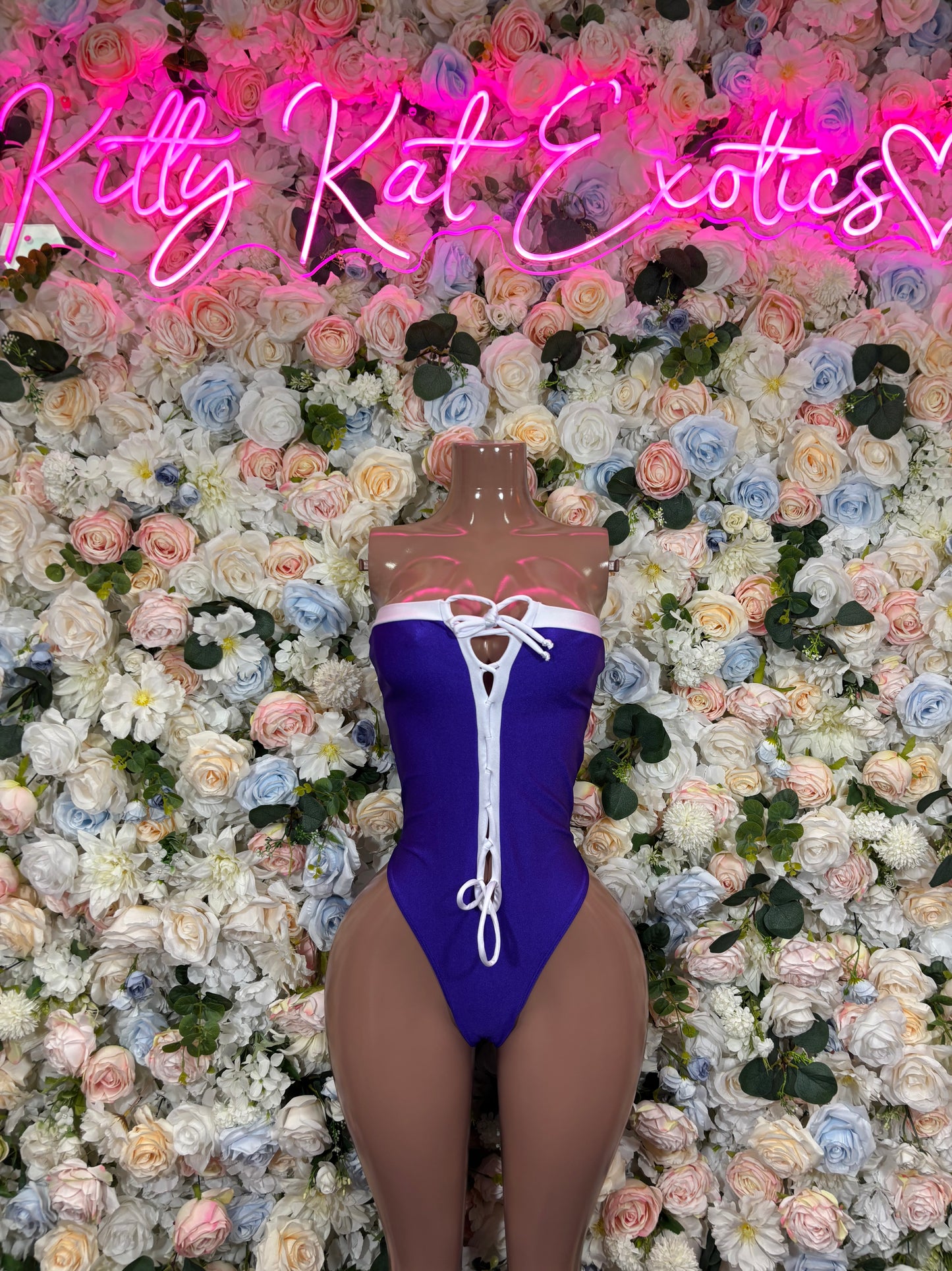 Blue one-piece bodysuit with white ribbon trim and lace-up front detail