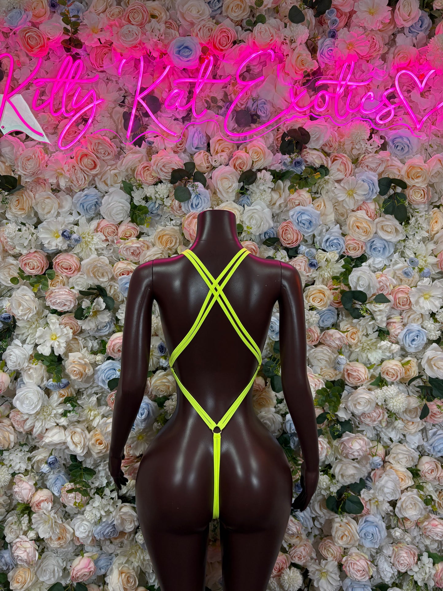 Neon green rhinestone bodysuit on mannequin, X-back strap design