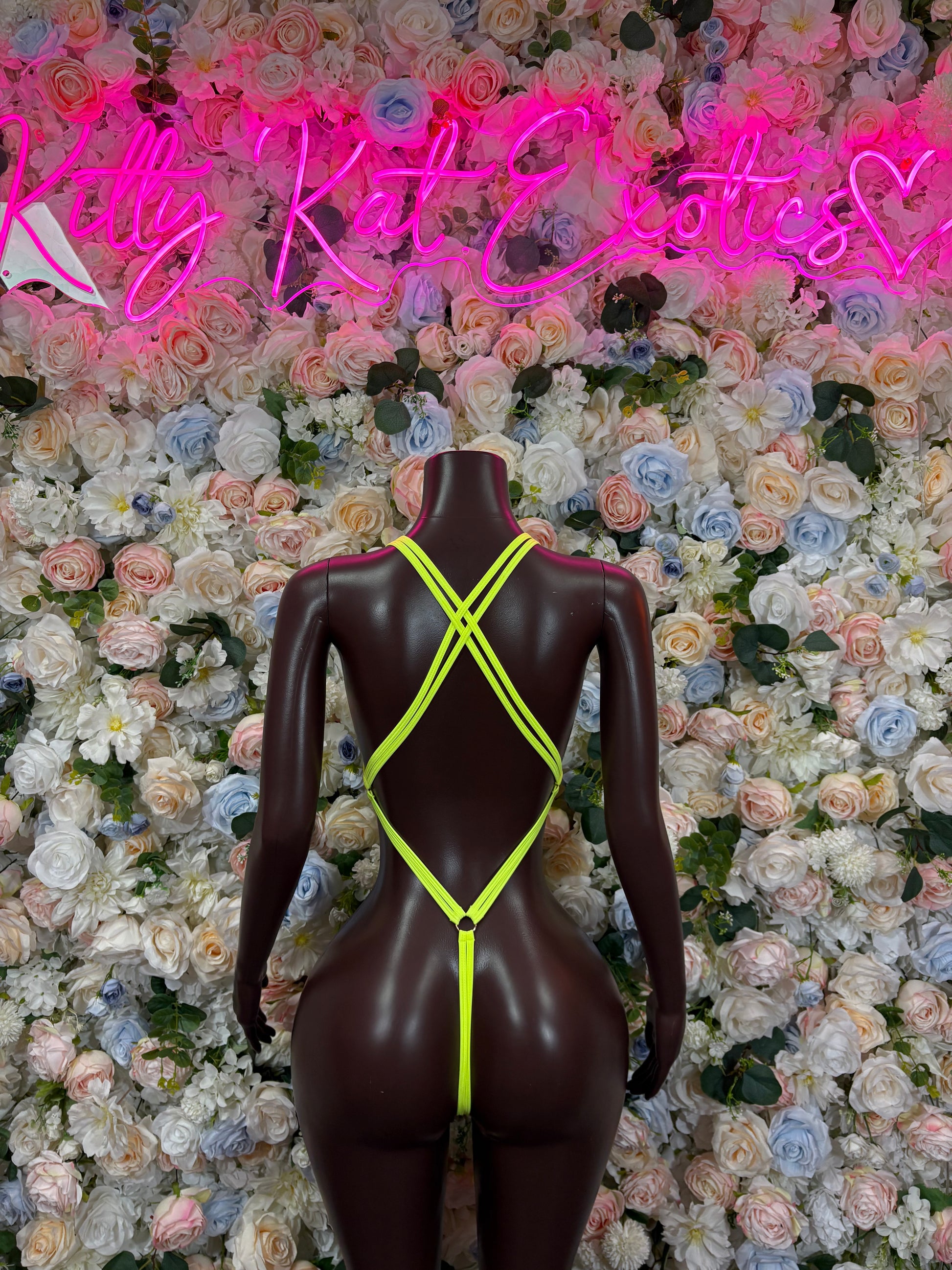 Neon green rhinestone bodysuit on mannequin, X-back strap design