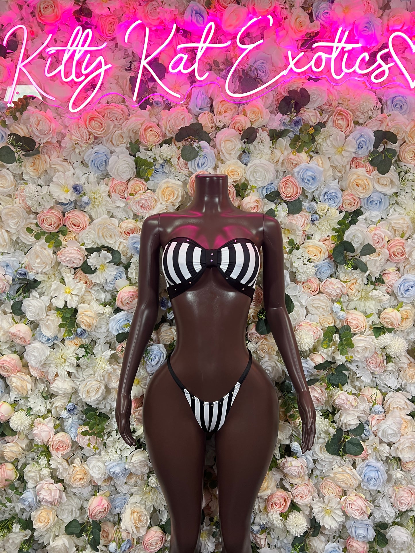 Black bodysuit-style bikini with white striped bra panel and string back, centered