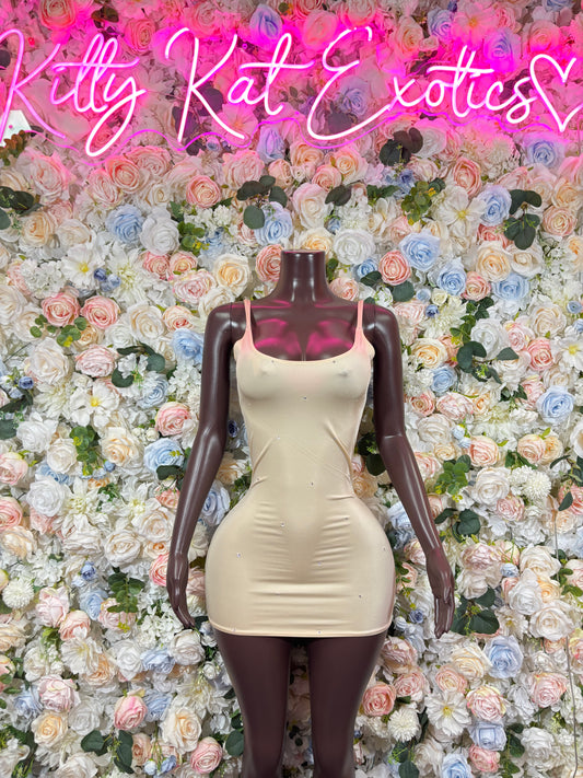 Cream sleeveless fitted mini dress on mannequin, short bodycon one-piece with scoop neckline