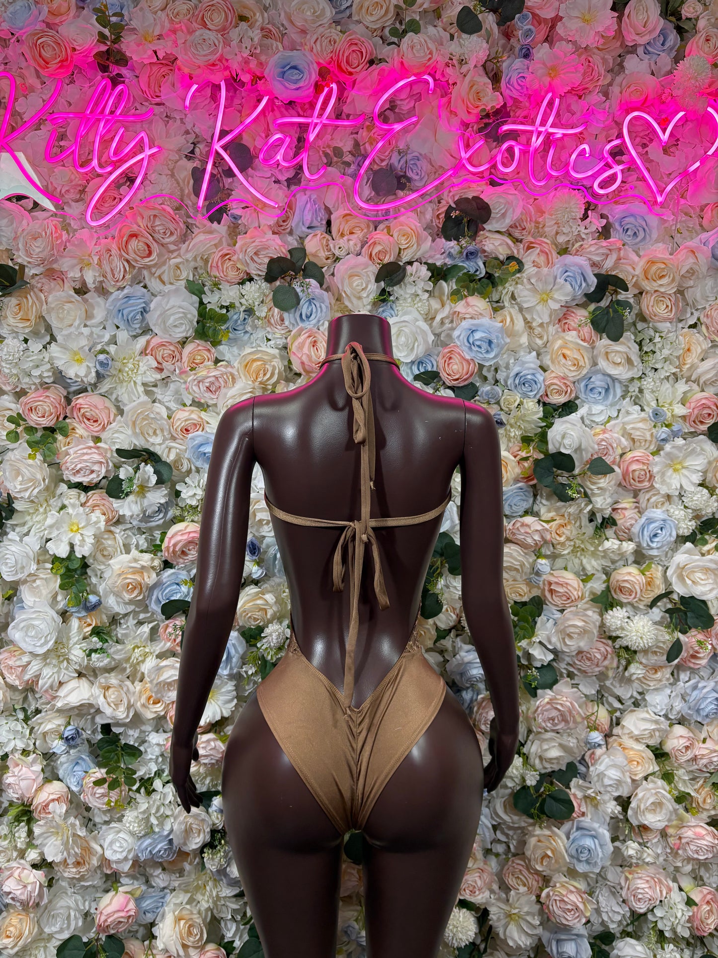 Tan lace bodysuit back view with crisscross straps and high-cut legs