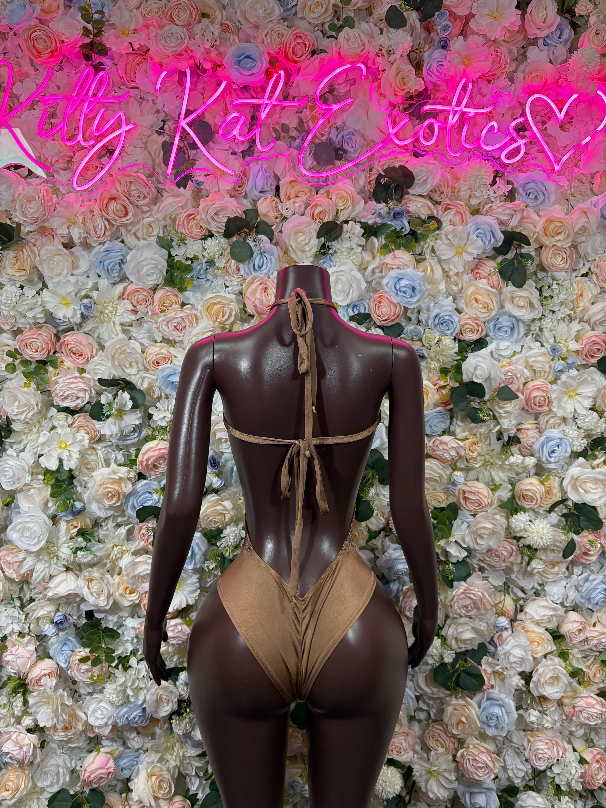 Tan lace bodysuit back view with crisscross straps and high-cut legs