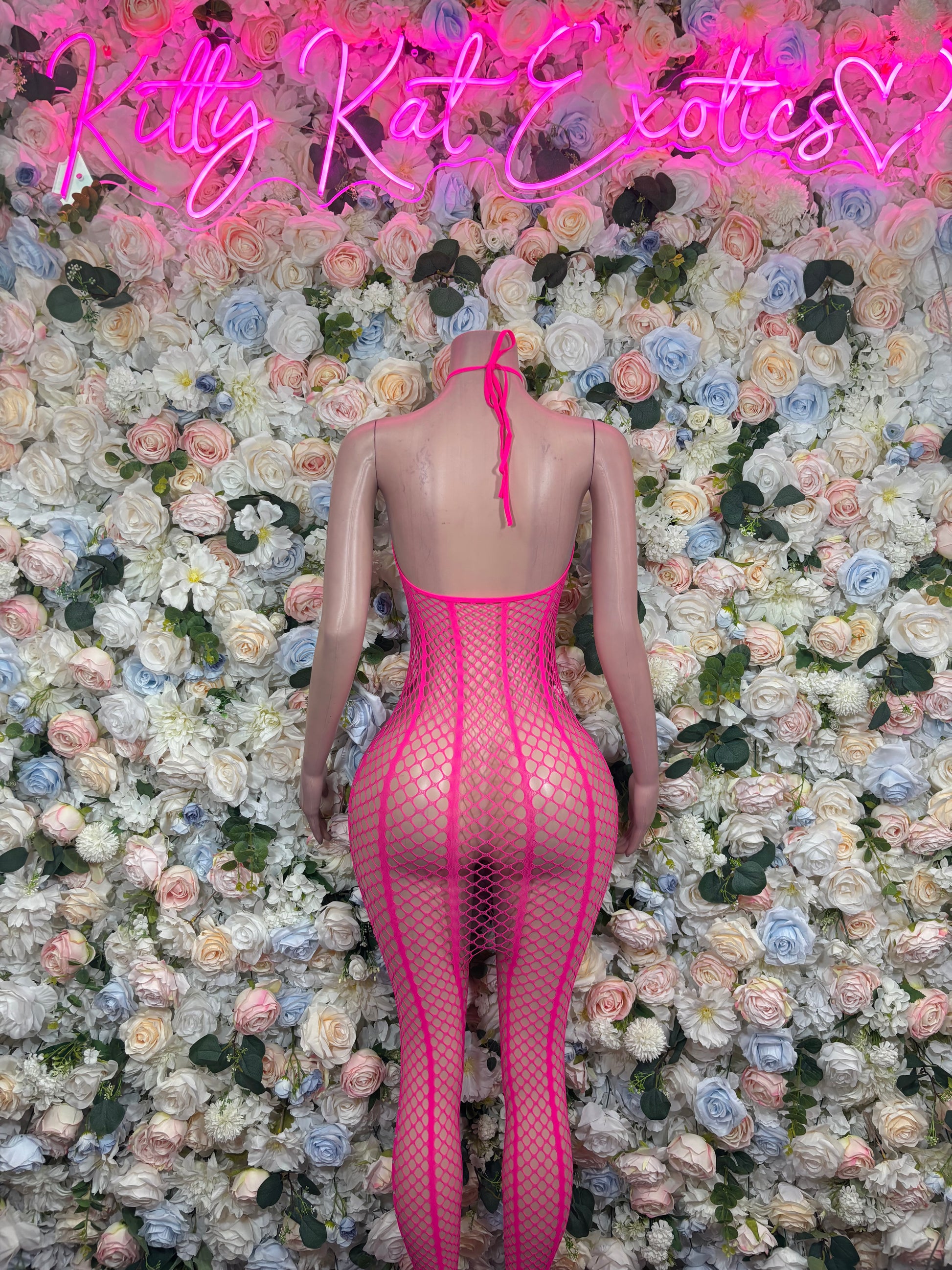 Hot pink fishnet catsuit with open-back cutout and adjustable neck tie