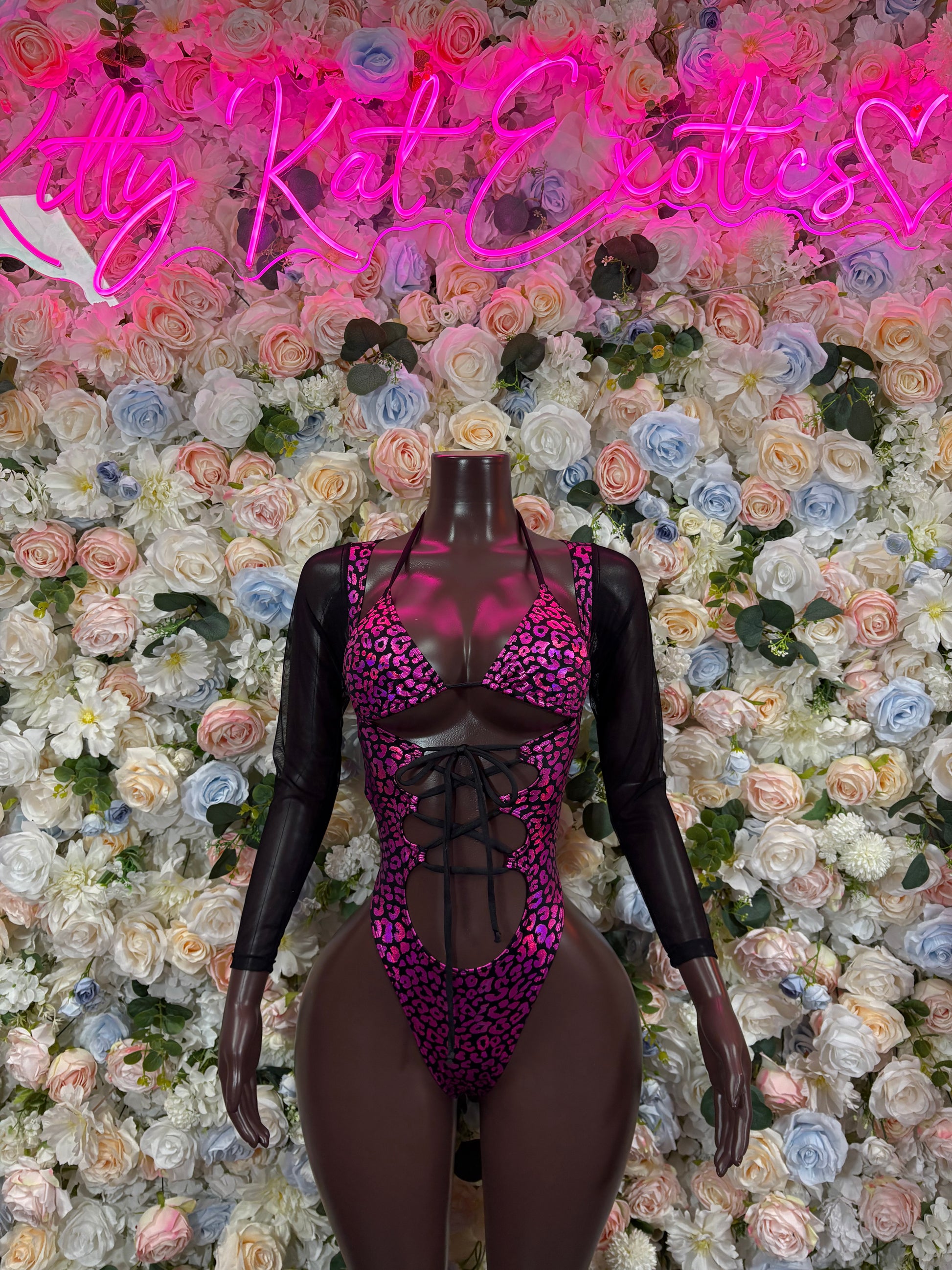 Purple leopard-print one-piece bodysuit with sheer long sleeves and lace-up front cutout