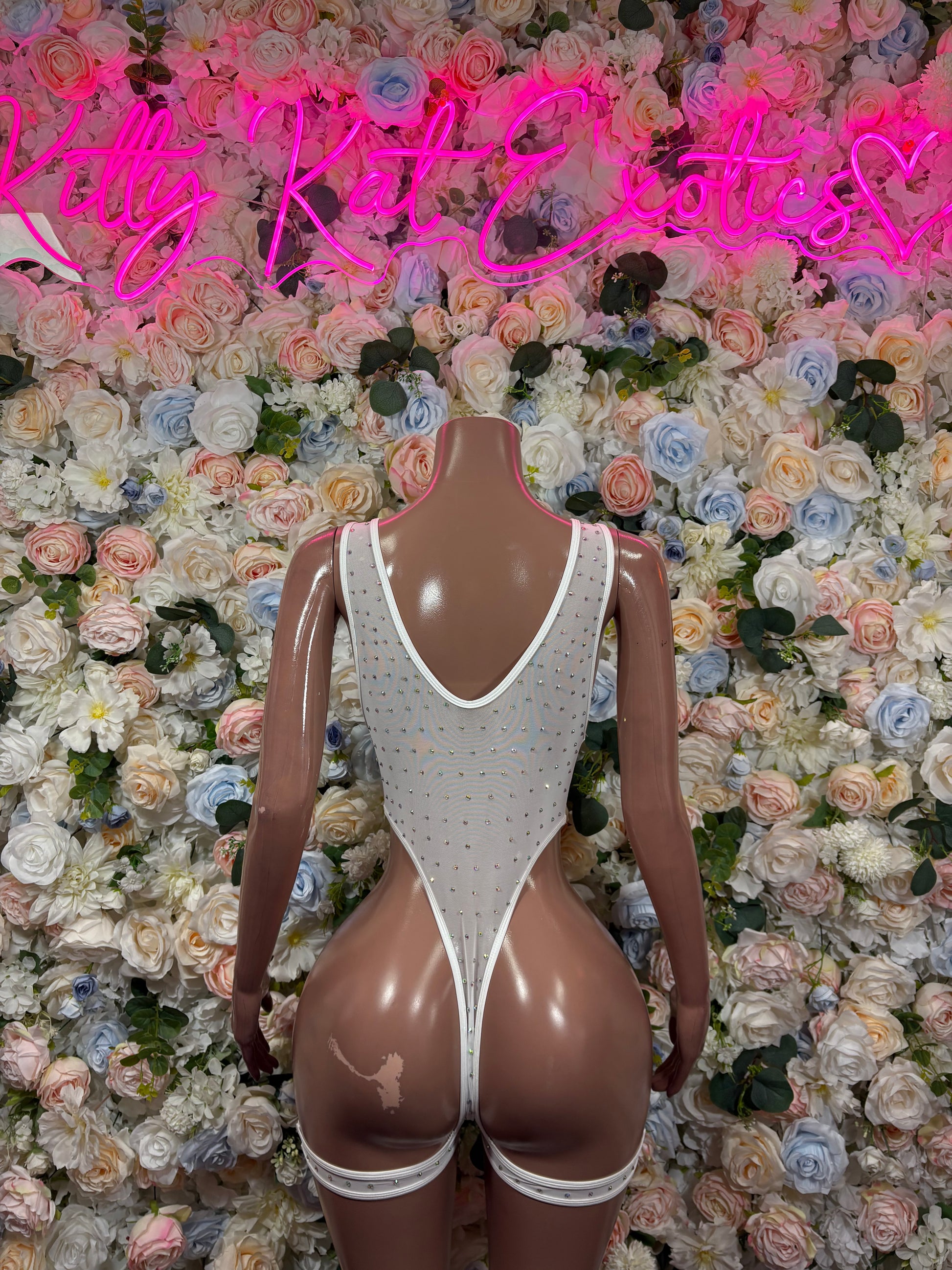 White rhinestone bodysuit close-up, sleeveless deep V front with glittered trim