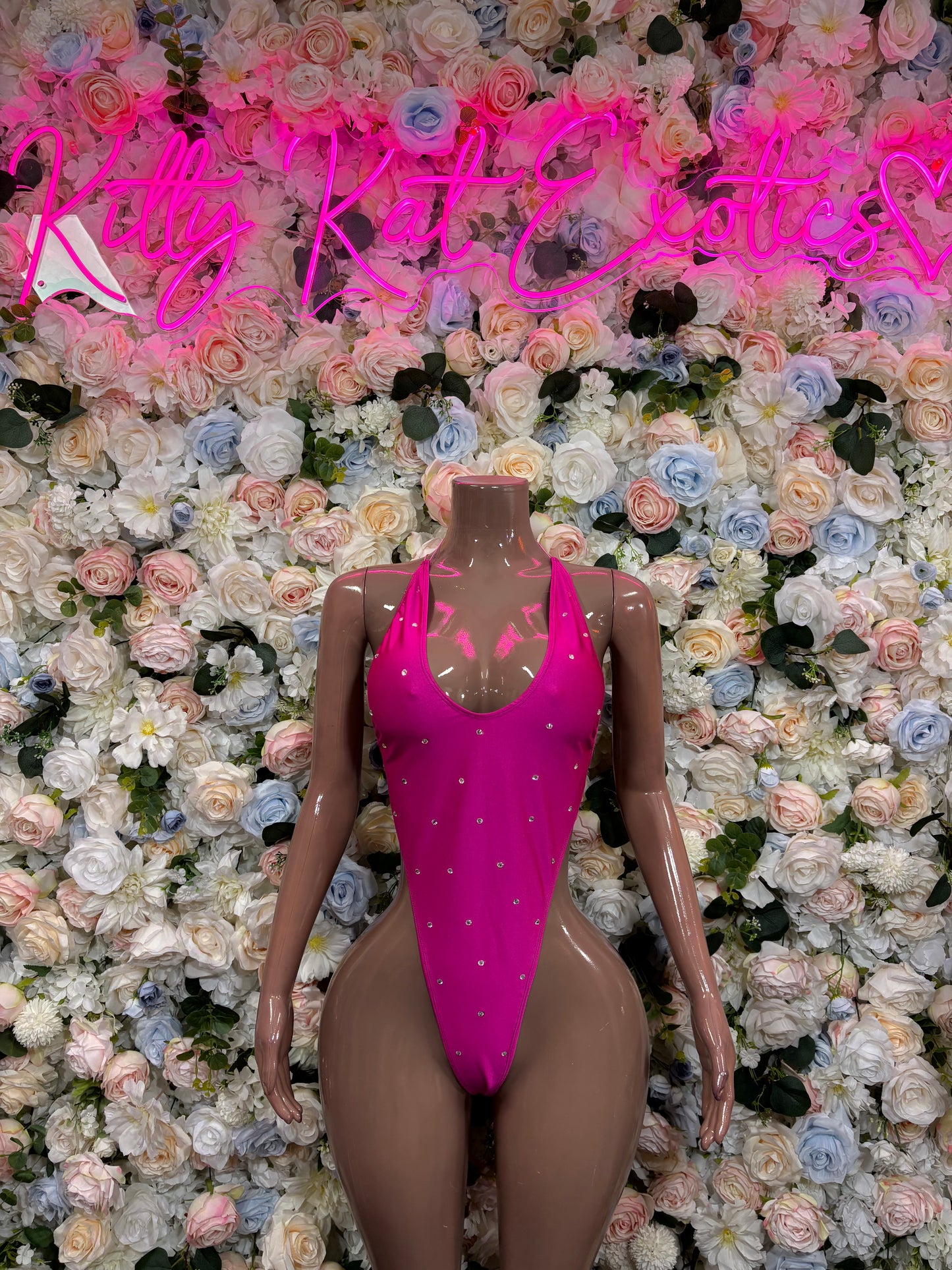 Pink one-piece bodysuit with scoop neckline, high-cut legs, rhinestone accents