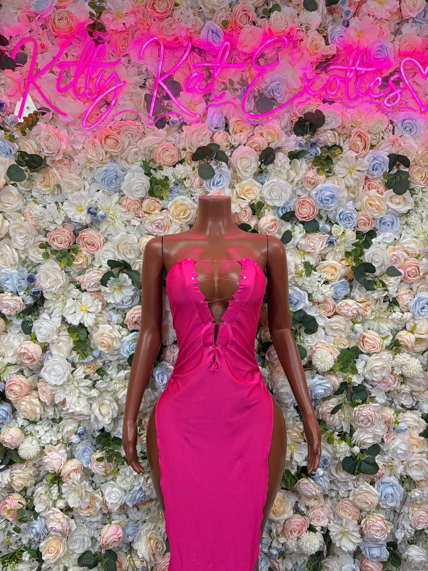 Magenta fitted gown with V-neck, ruched bodice, and front slit on mannequin