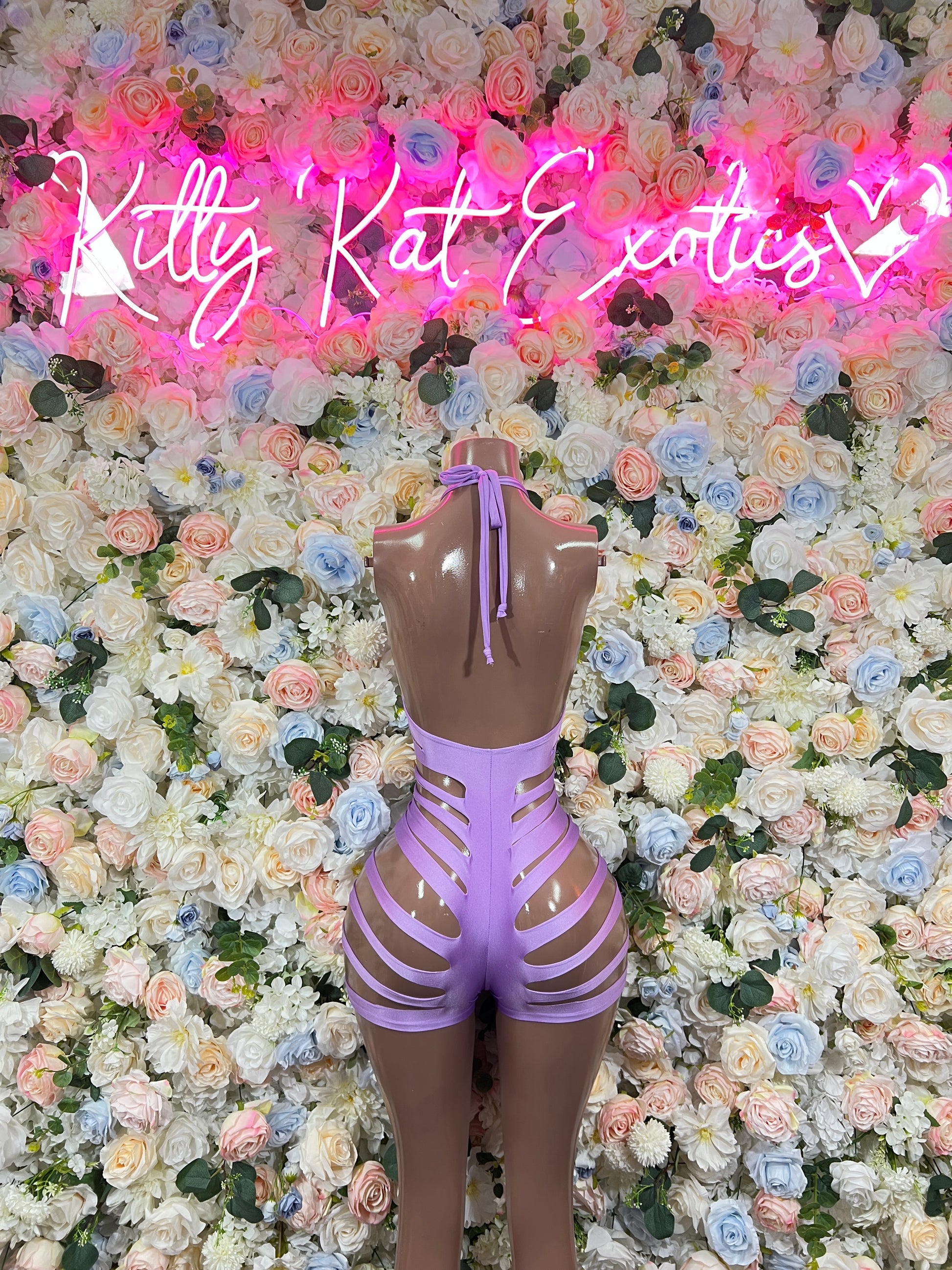 Purple one-piece bodysuit with long sleeves, back straps, and lace-up lattice legs