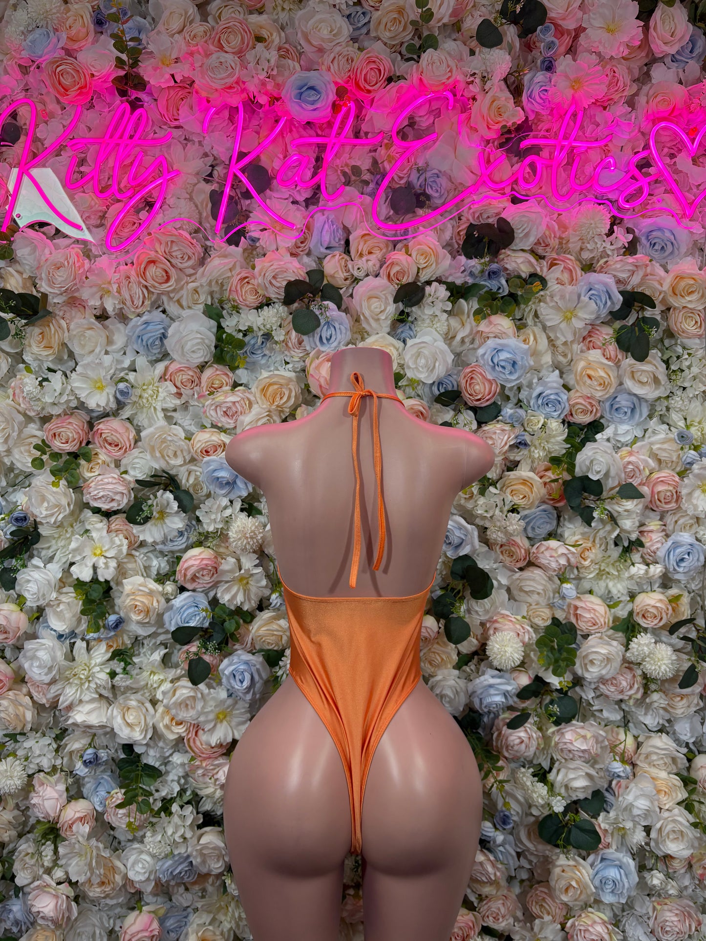 Orange one-piece bodysuit with plunging V neckline, thong cut, thin straps