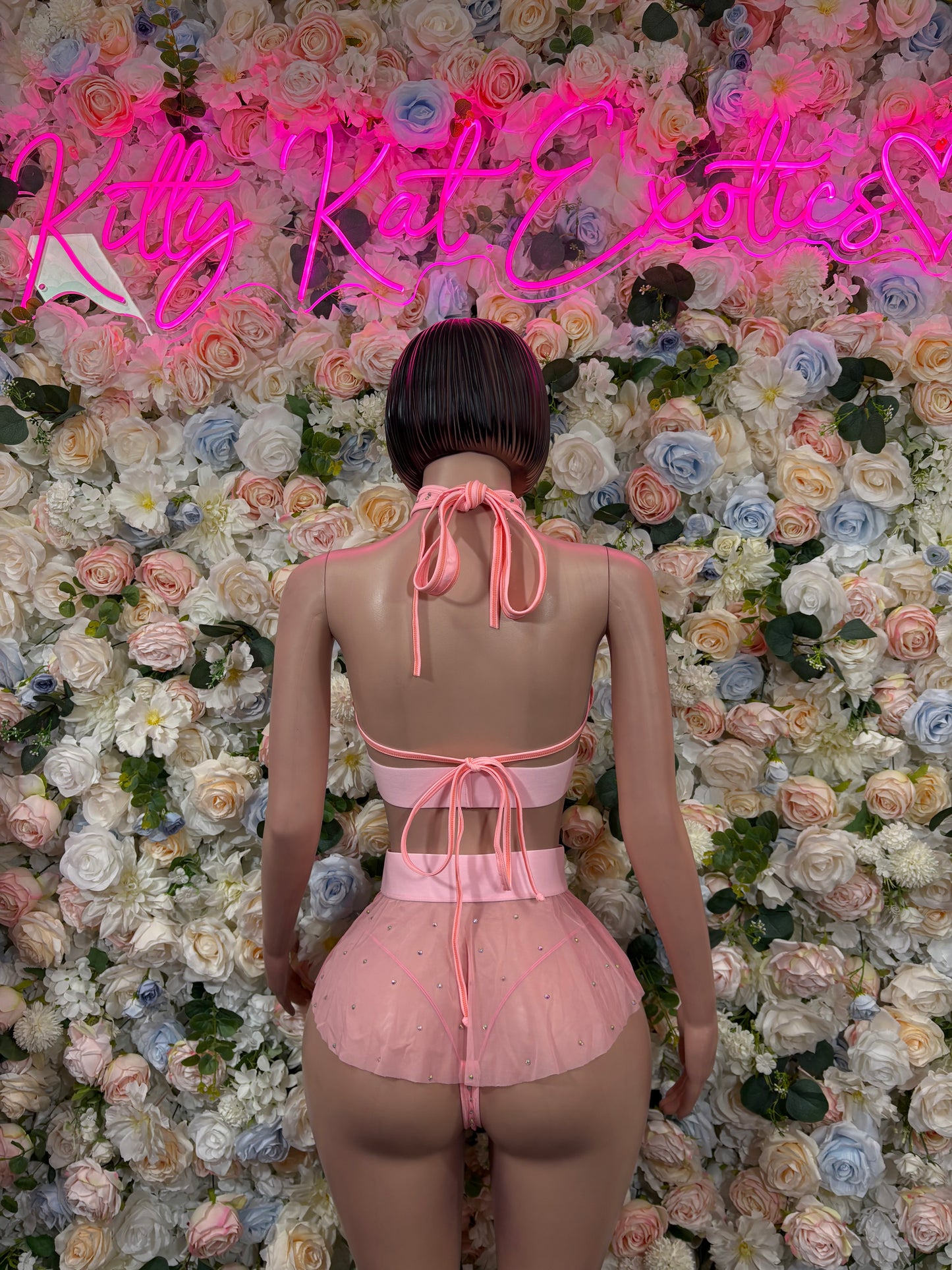 Back view of pink rhinestone halter bra top and layered mini skirt set
