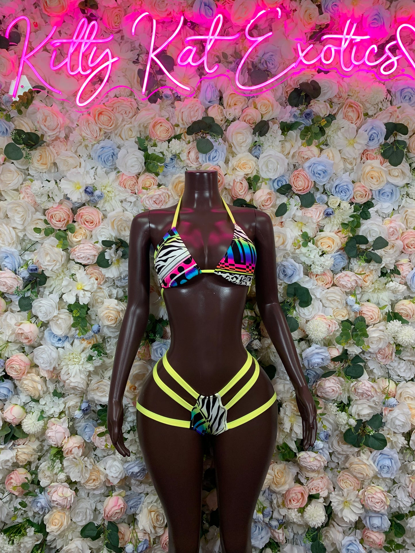 Dark brown two-piece bodysuit with neon green trim and rainbow-pattern chest panel