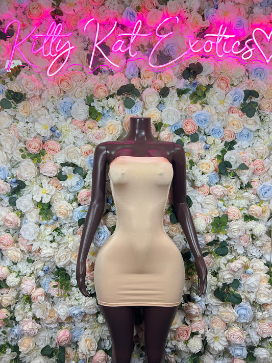 Beige bodycon mini dress on mannequin, fitted sweetheart neckline, sleeveless.