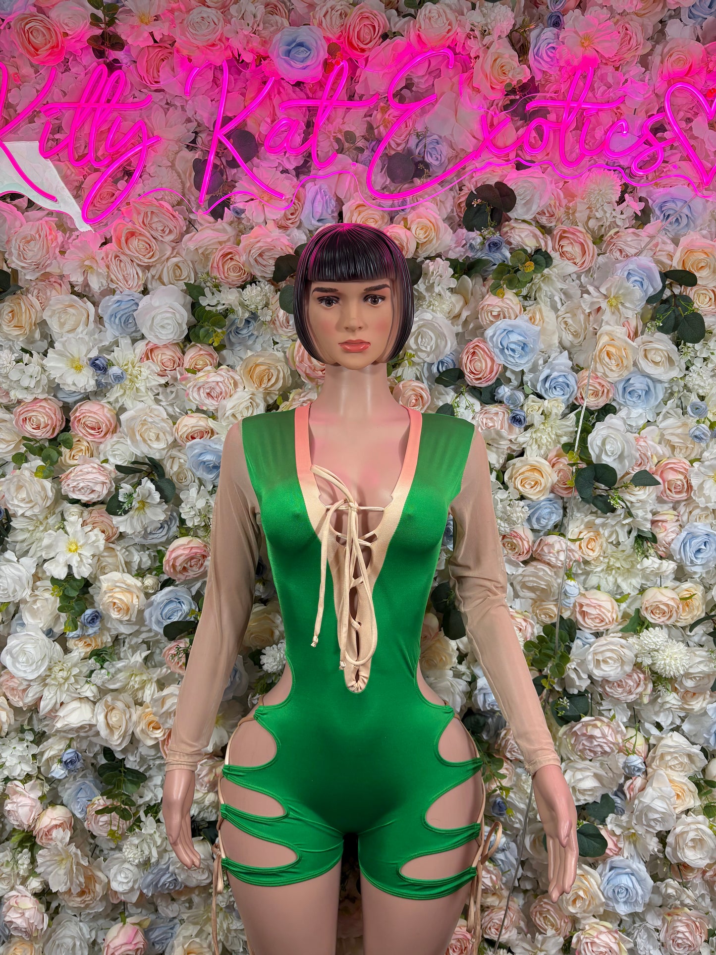 Green lace-up bodysuit with deep chest cutout and side openings, long sleeves
