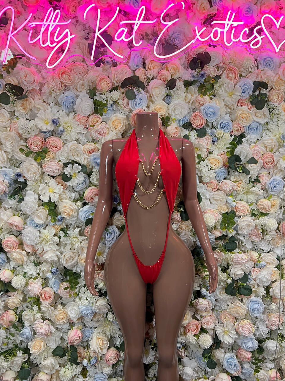 Red front slingshot bodysuit with plunging neckline, thong cut, and chain accents