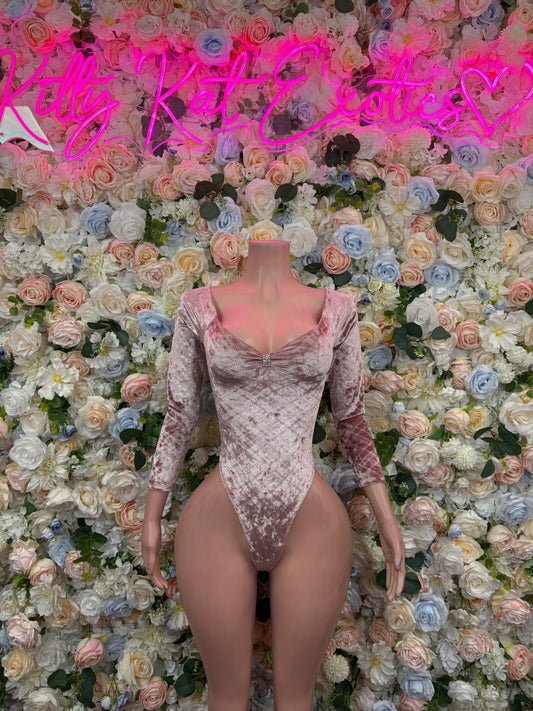 Nude velvet bodysuit with long sleeves, V-neck, and high-cut thong-style leg openings.