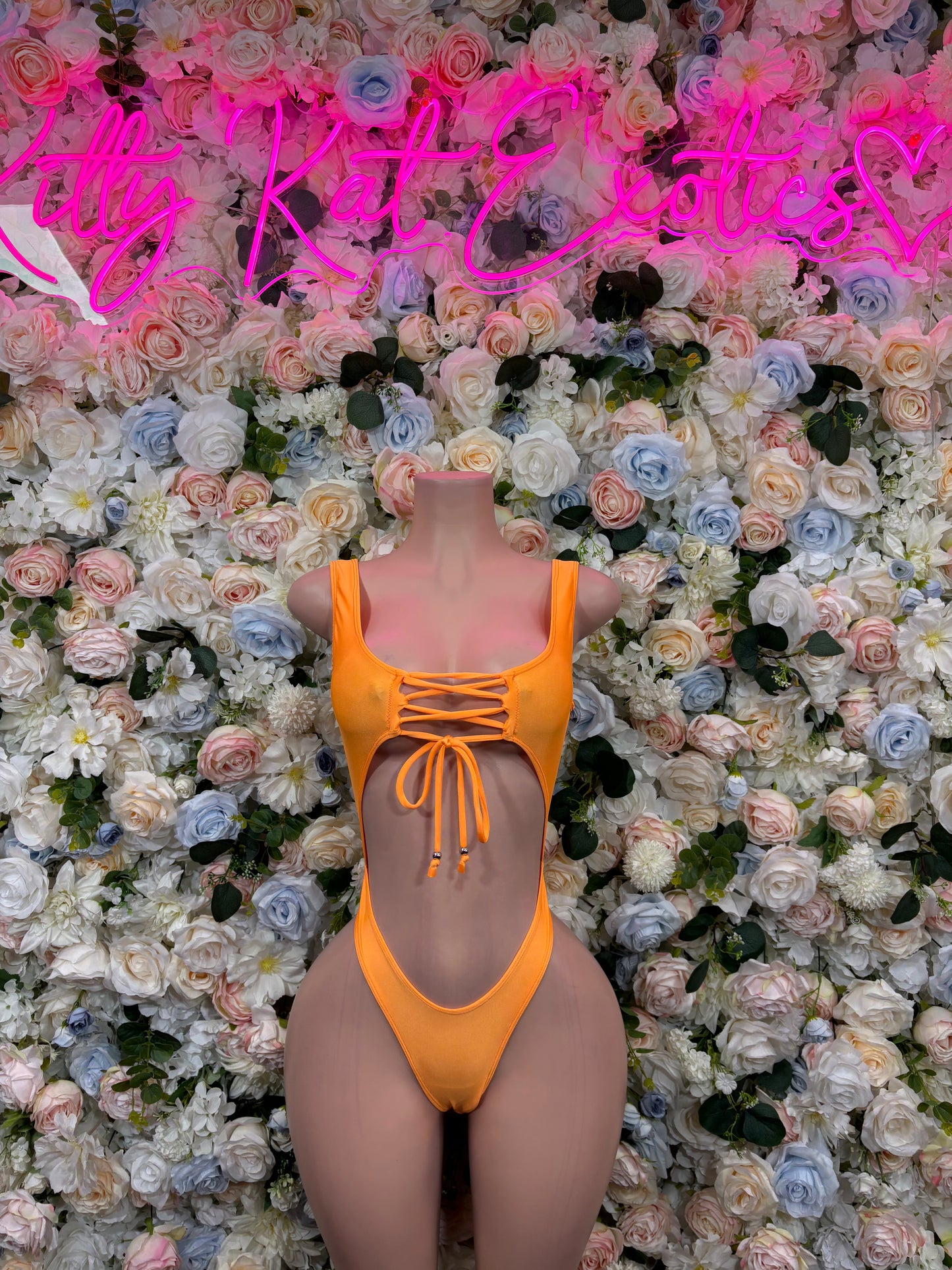 Orange one-piece bodysuit with square neckline, lace-up sides, and thin shoulder straps