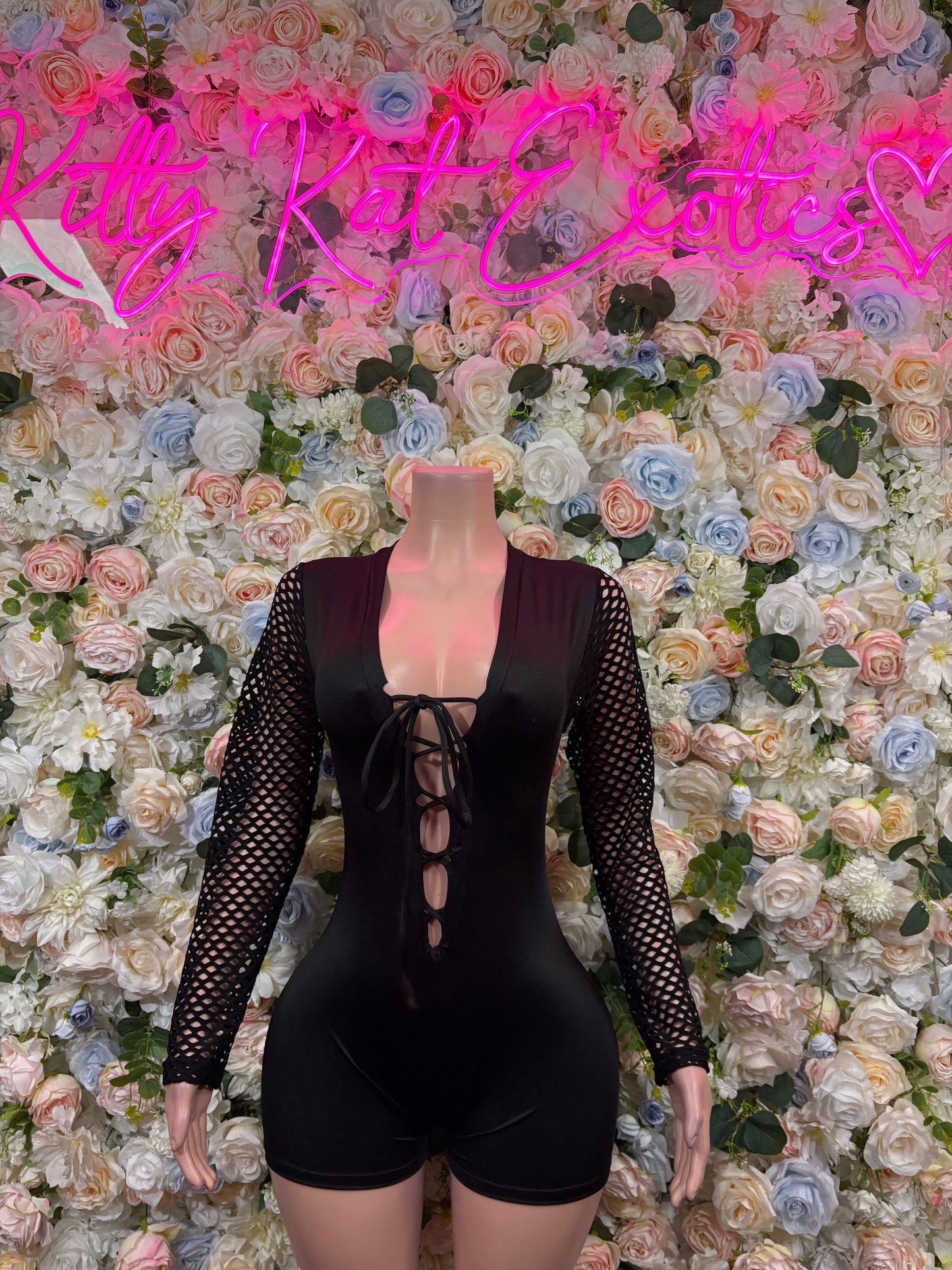 Black lace-sleeve one-piece bodysuit with crisscross front lace-up and shorts cut