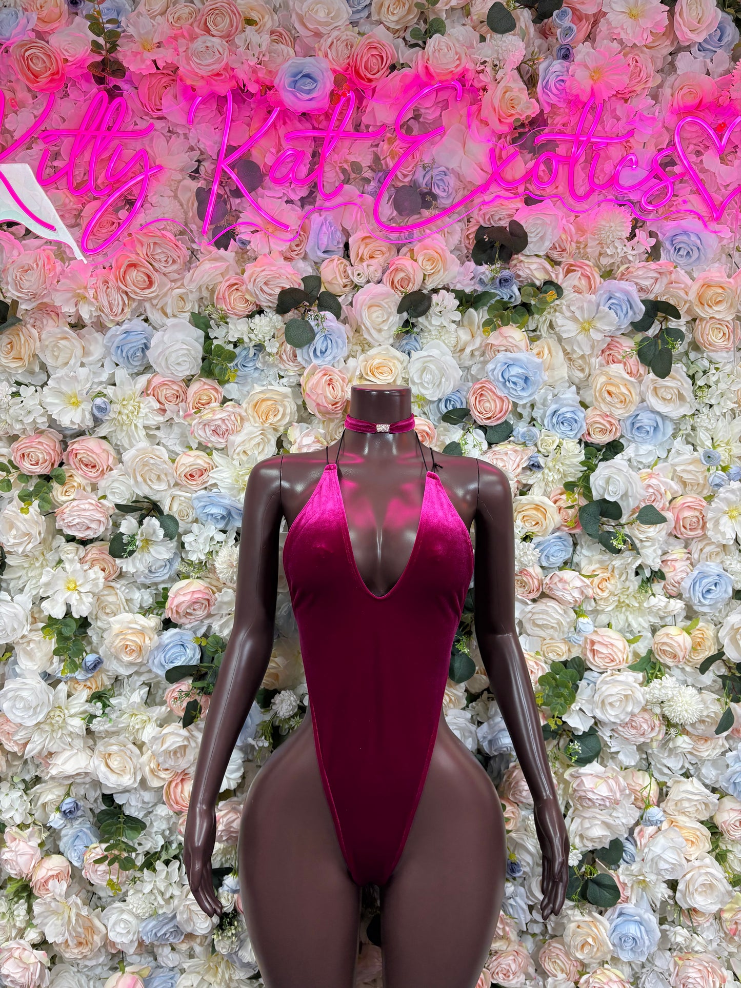 Purple halter one-piece bodysuit with deep V neckline on mannequin