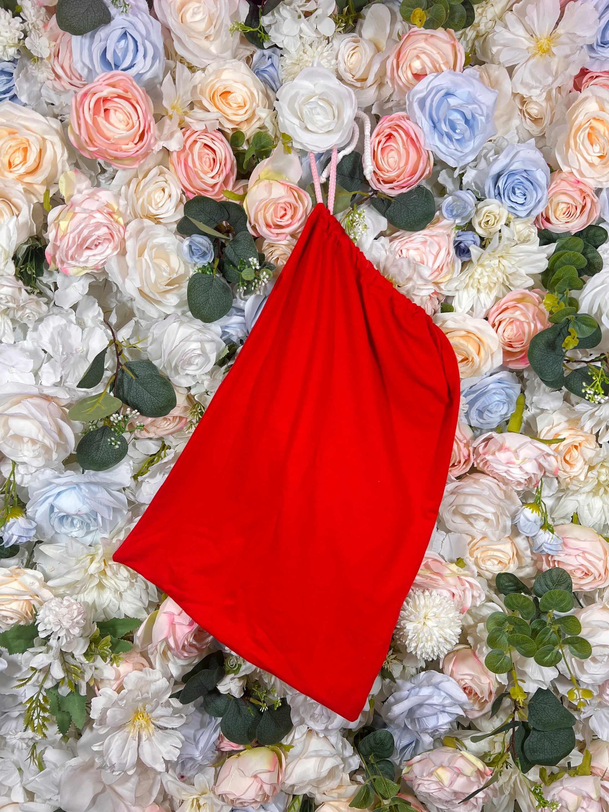 Red fabric money-pouch with gathered top and strap, solid red