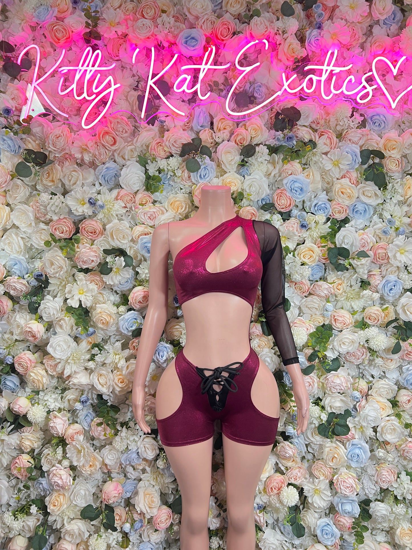 Burgundy halter bodysuit with cutouts and lace-up front, paired with black mesh sleeves