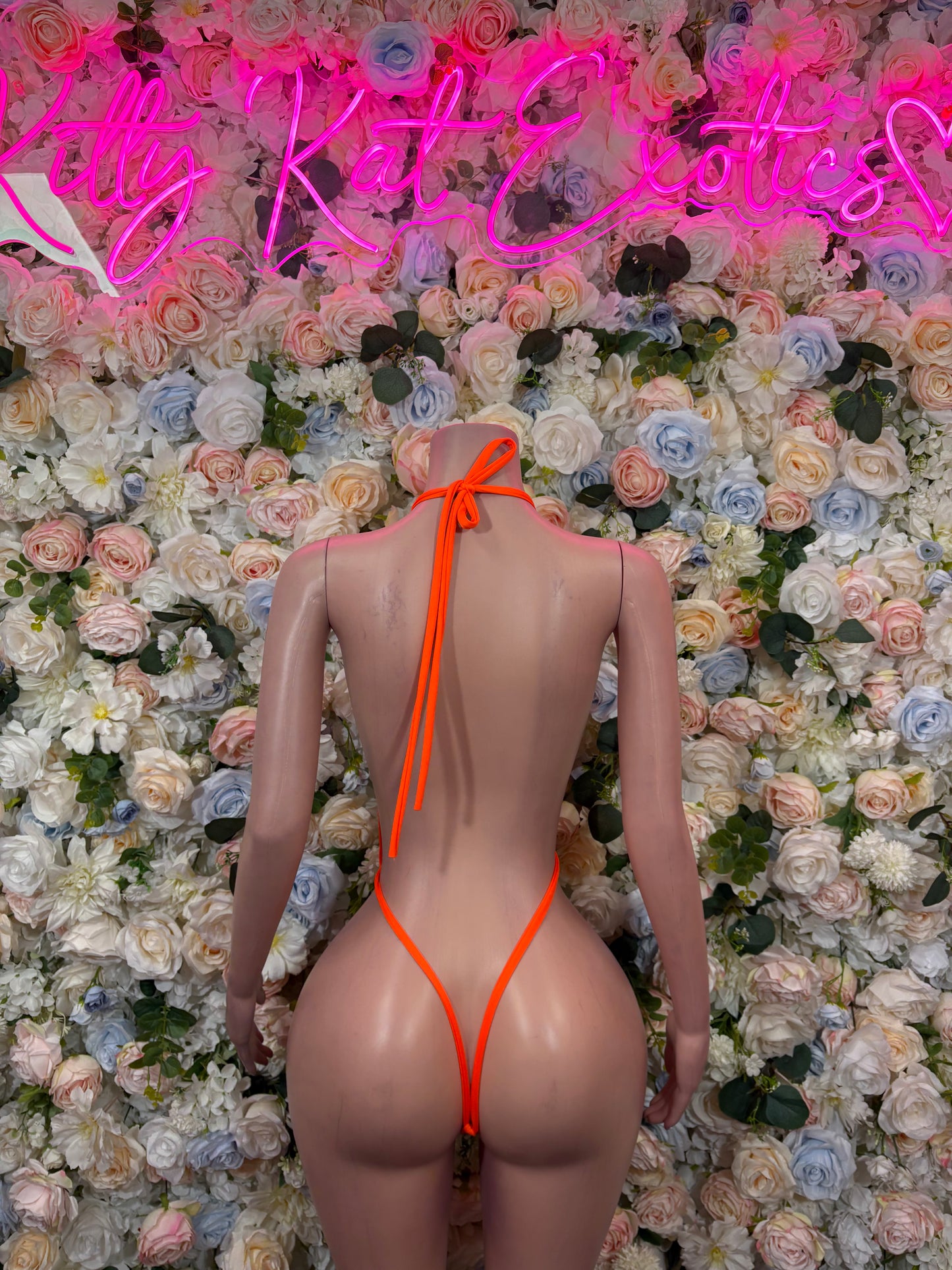 Orange one-piece bodysuit with open back and bow-tied straps