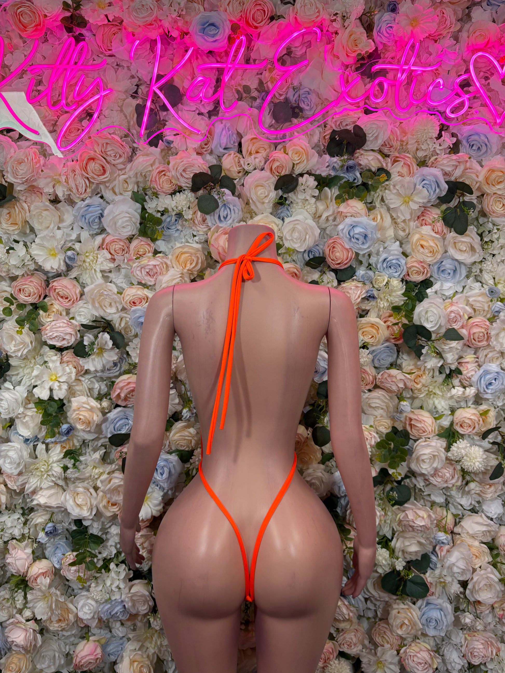 Orange one-piece bodysuit with open back and bow-tied straps