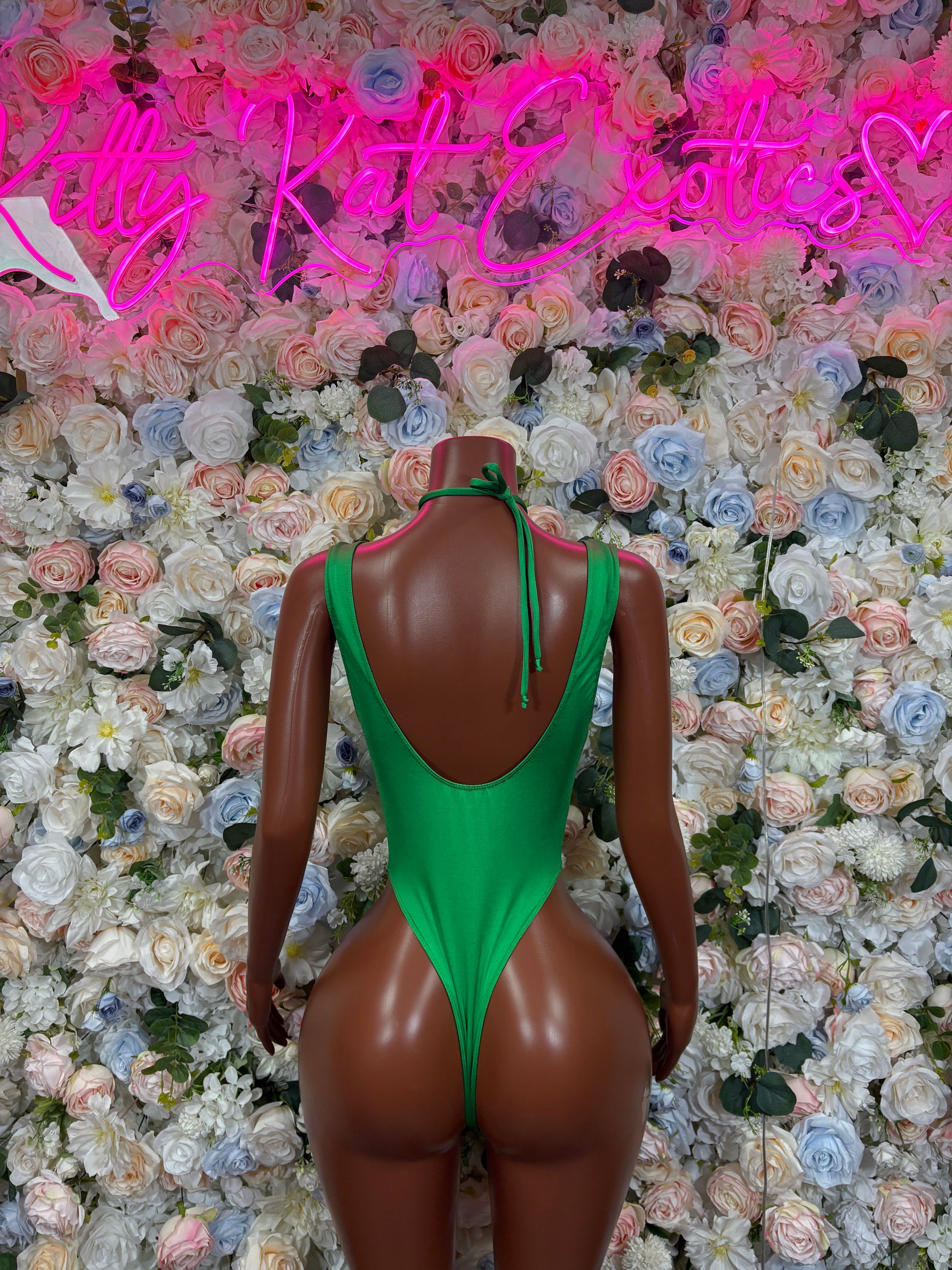 Green strappy bodysuit with open back and high neckline