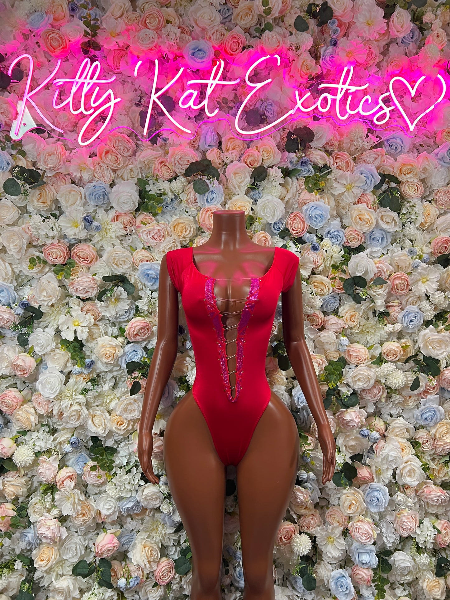 Red one-piece bodysuit with long sleeves, deep V neckline, thong cut, lace-up detail