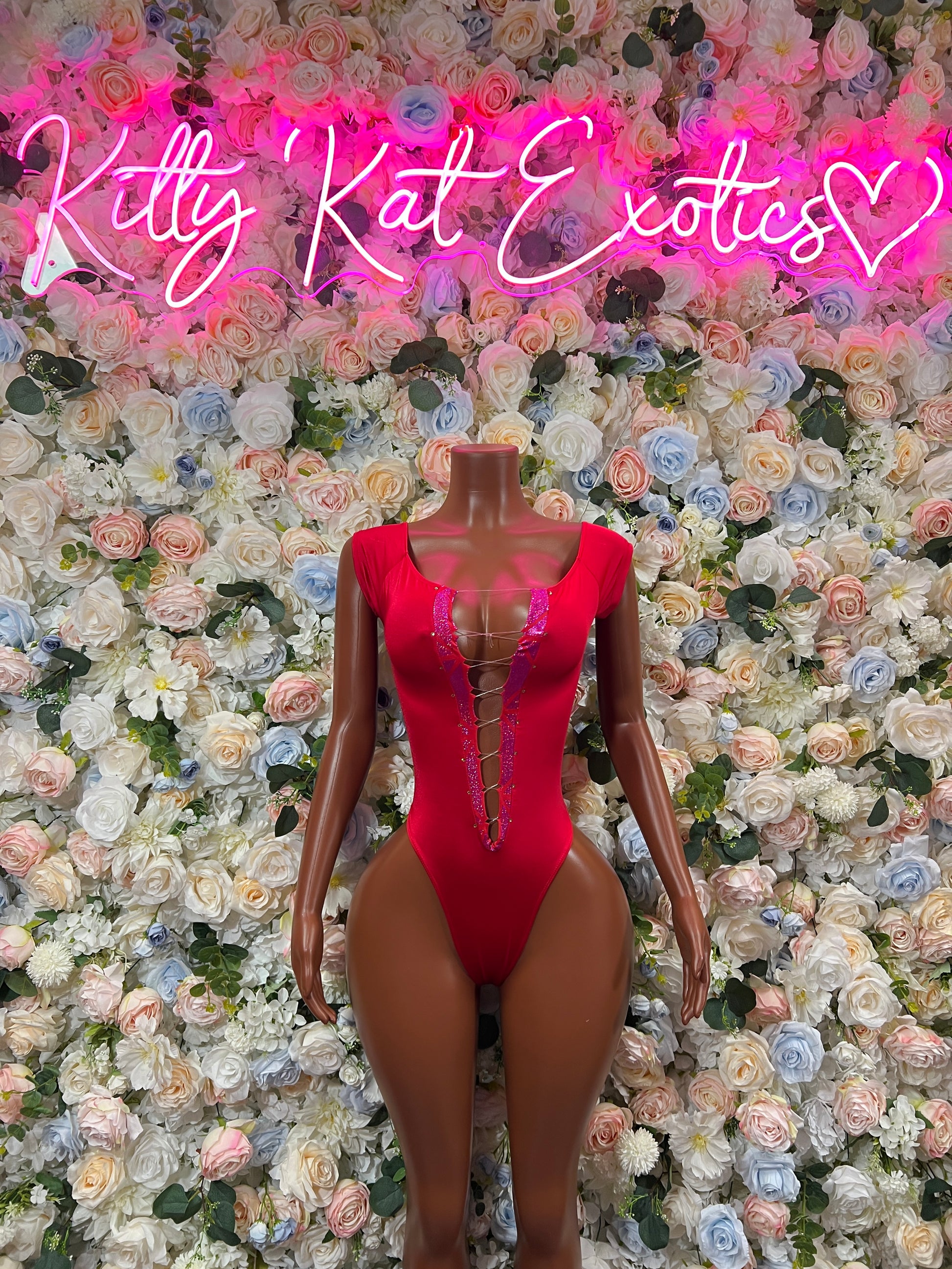 Red one-piece bodysuit with long sleeves, deep V neckline, thong cut, lace-up detail