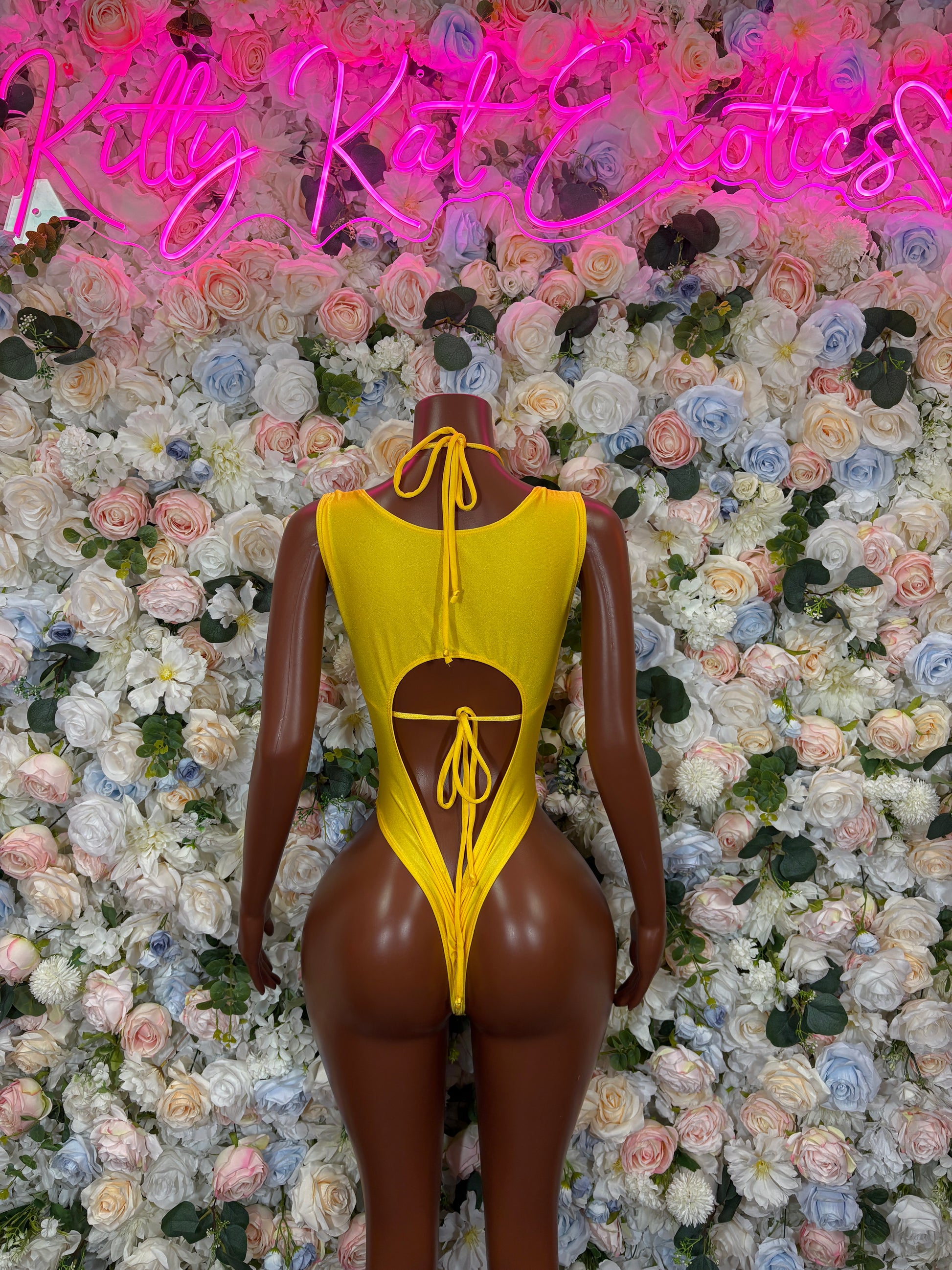 Yellow metallic halter bodysuit with open back and lace-up chest detail.