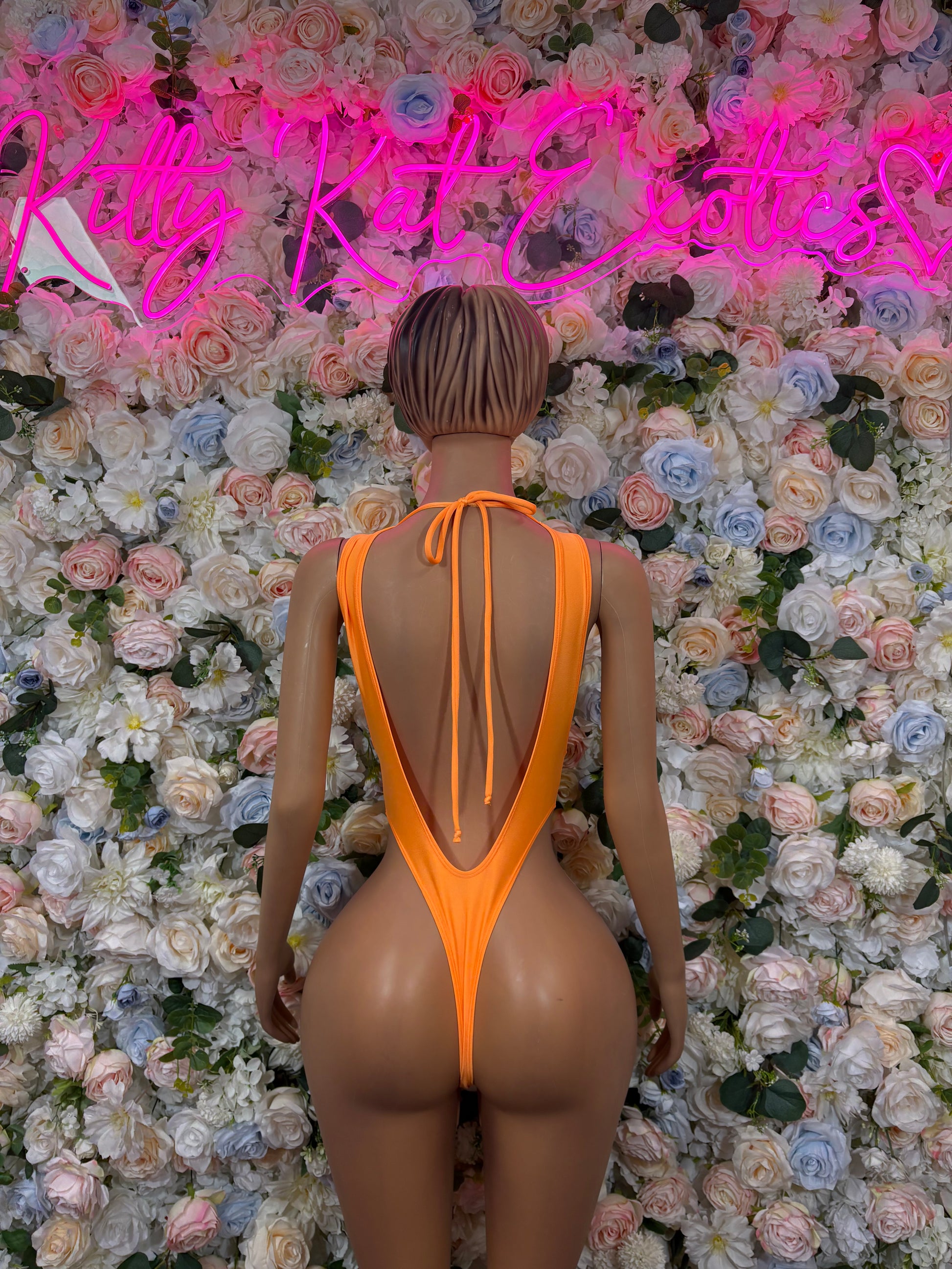 Orange one-piece bodysuit back view with V-shaped open back and thin straps