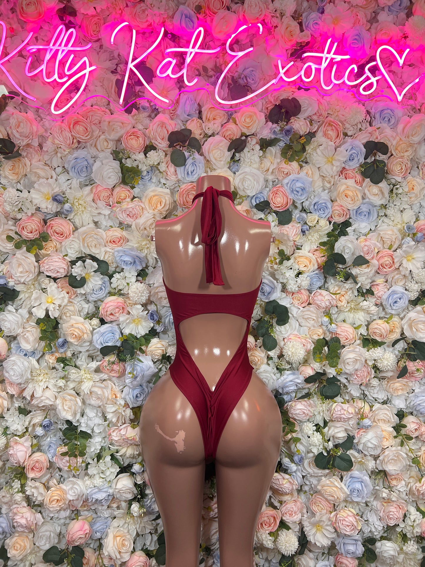 Burgundy one-piece bodysuit with halter straps and high-cut open back