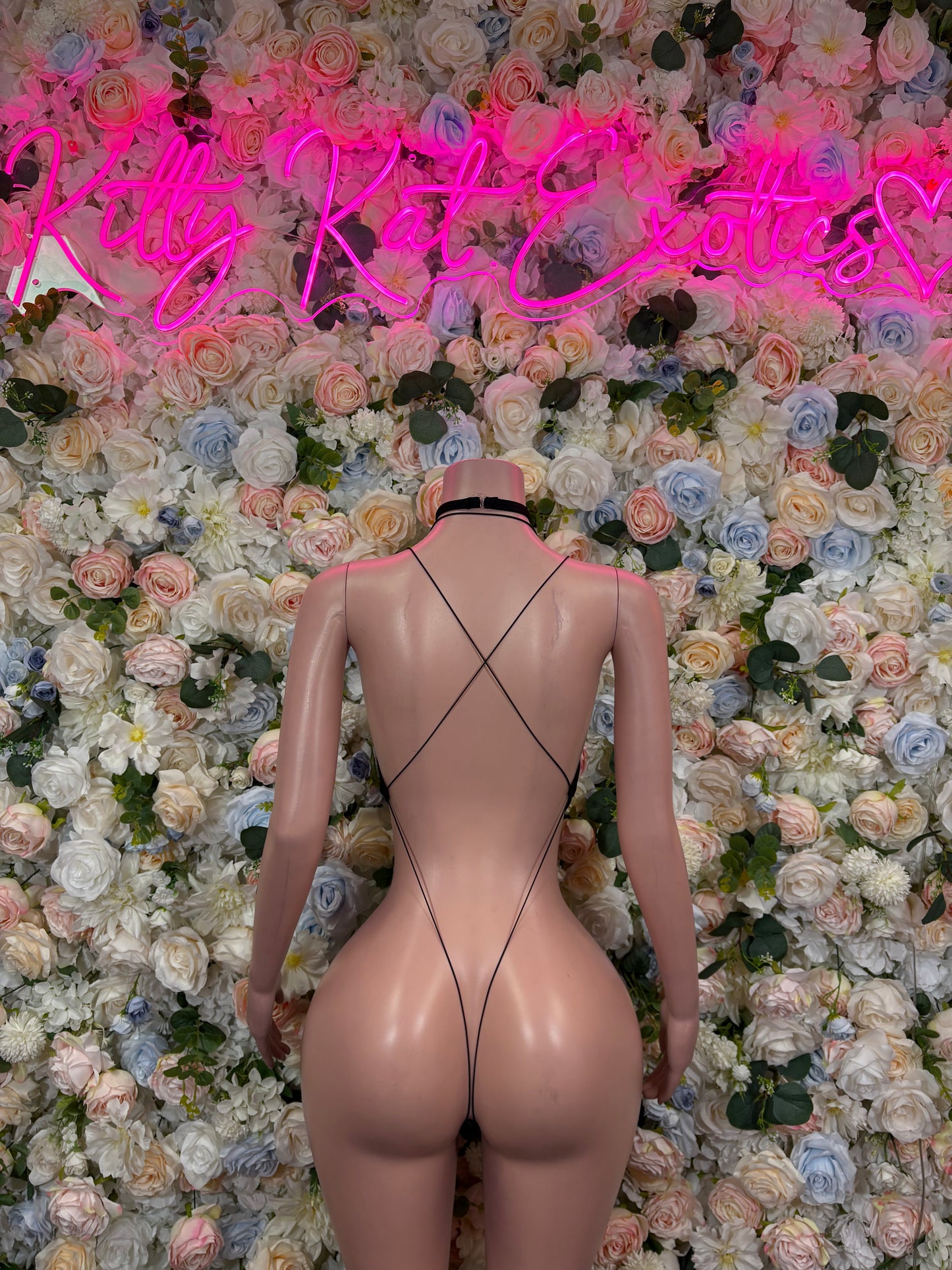 Black lace bodysuit back view with crisscross straps and high-cut legs