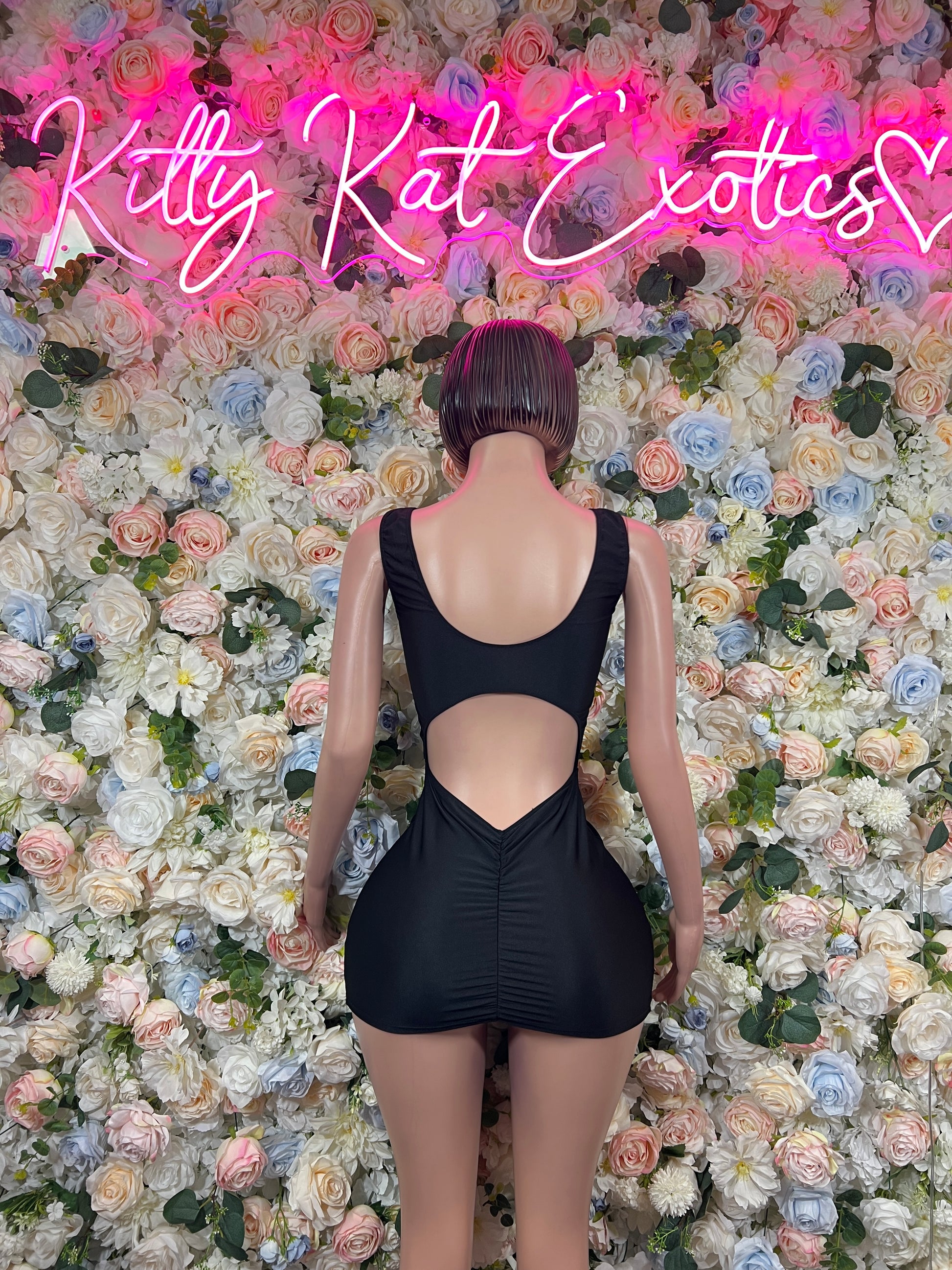 Black sleeveless mini dress with open back and deep V front cutout