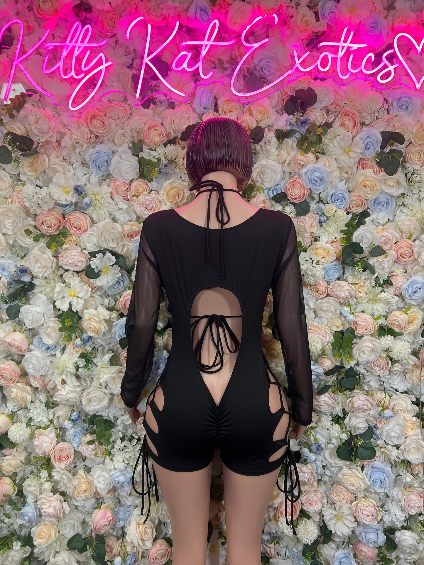 Black bodysuit back view with sheer sleeves and crisscross lace-up center